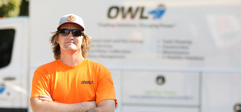 Aerial view of a small beach area with boats floating near the shoreline and green marshland surrounding a water body.