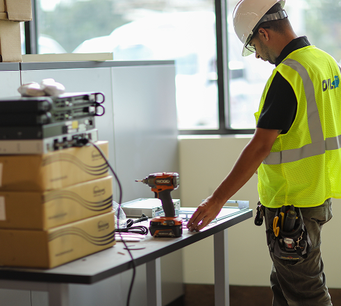Four colleagues in a modern office discussing and pointing at a large timeline chart on a whiteboard.