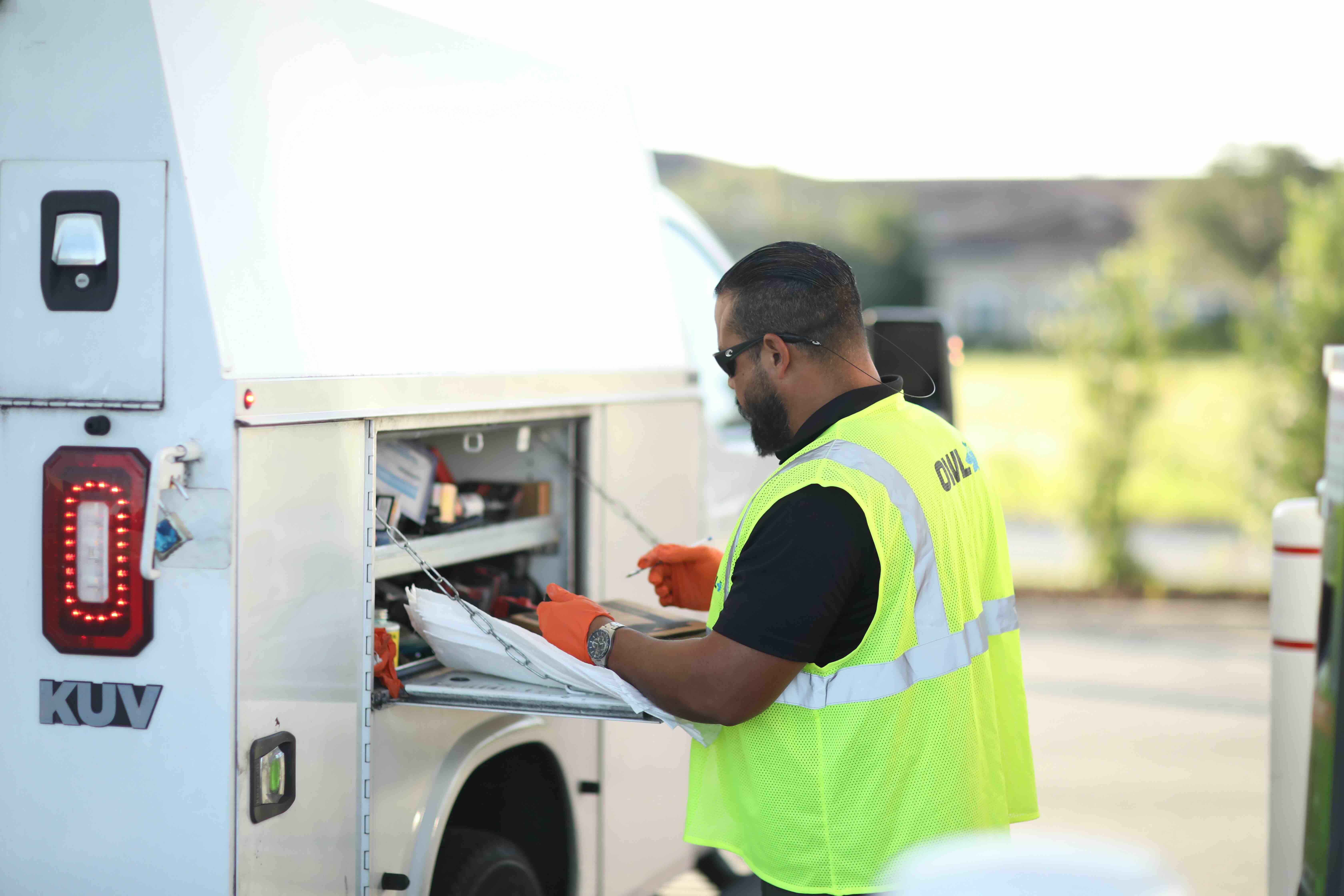 Concrete dock extending into calm water with boat fueling station and cleats along the edge under a blue sky.