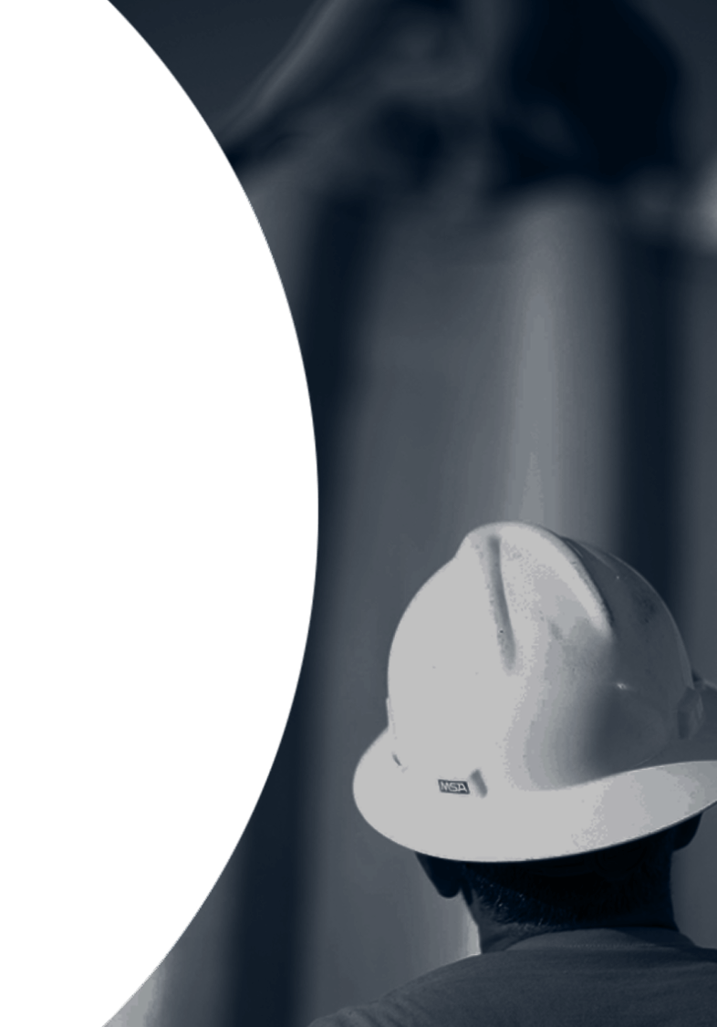 Rear view of a construction worker wearing a white hard hat, looking up.