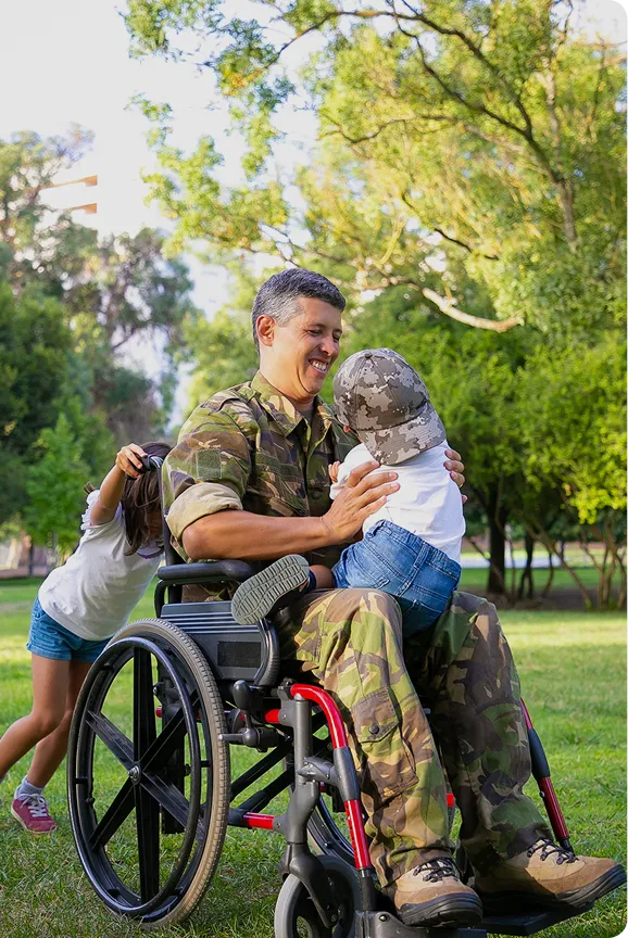 Veteran in a wheelchair spending time outdoors with his children
