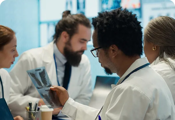 Medical team reviewing an X-ray together in a clinical setting