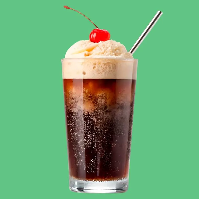 Iced coffee topped with a bright red cherry, served in a clear glass with condensation on the outside.