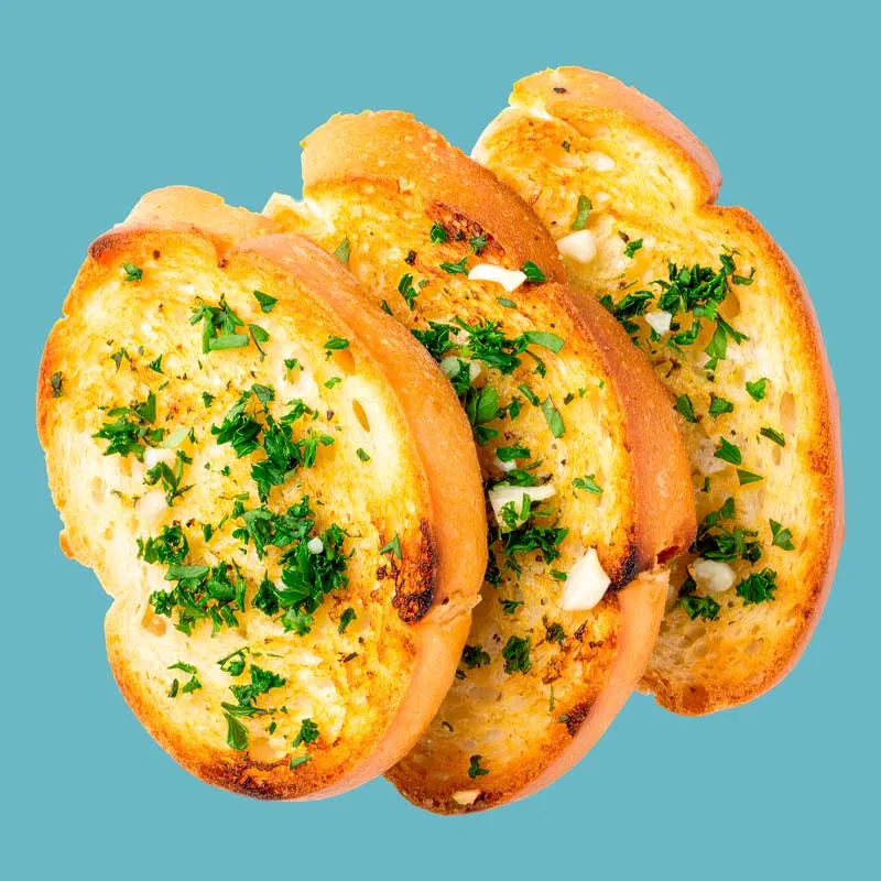 Three slices of bread topped with a sprinkle of fresh herbs, arranged neatly on a wooden cutting board.
