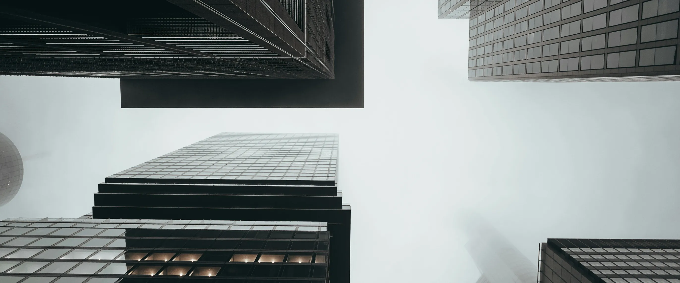 Foggy city skyscrapers viewed from street level — banking and finance district architecture