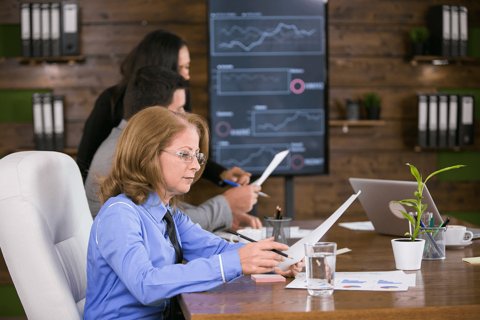 Business team reviewing financial reports and analytics dashboards during a fintech strategy meeting.