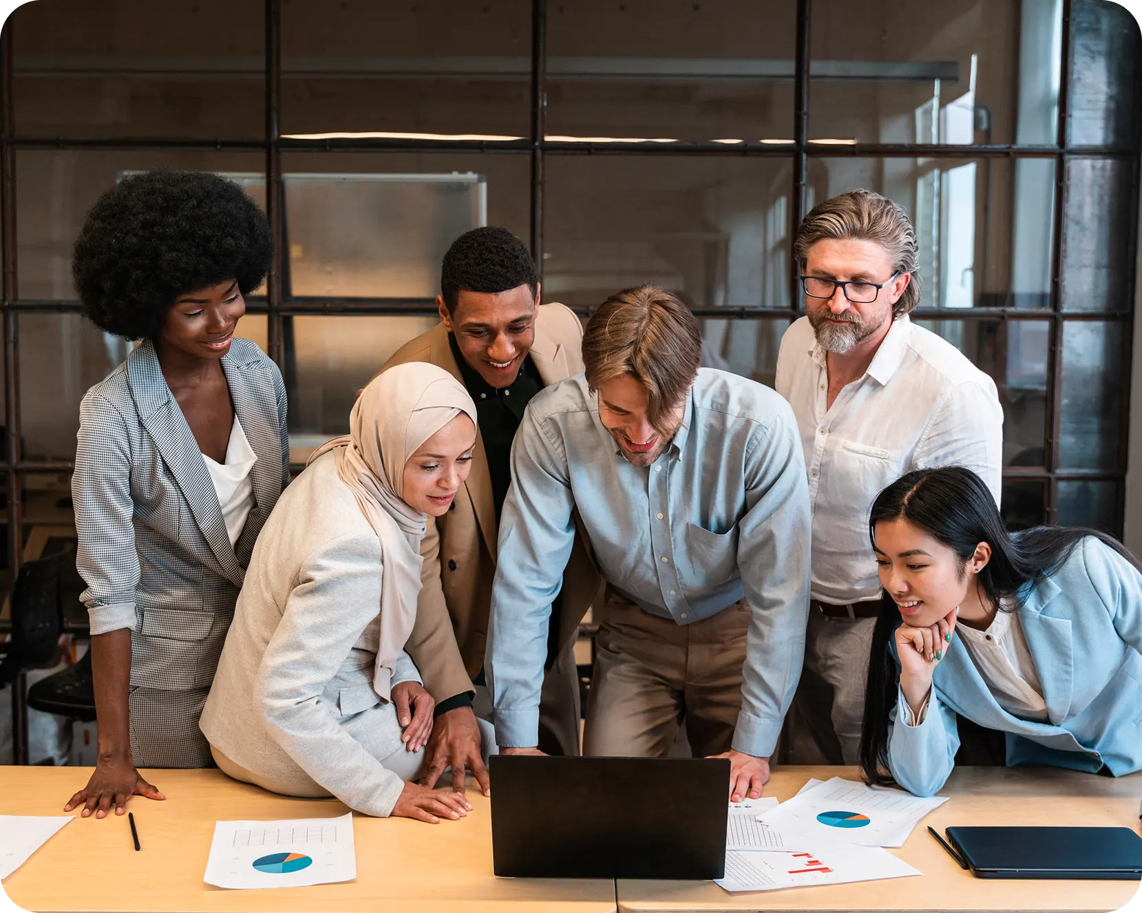 a group of people looking at a laptop