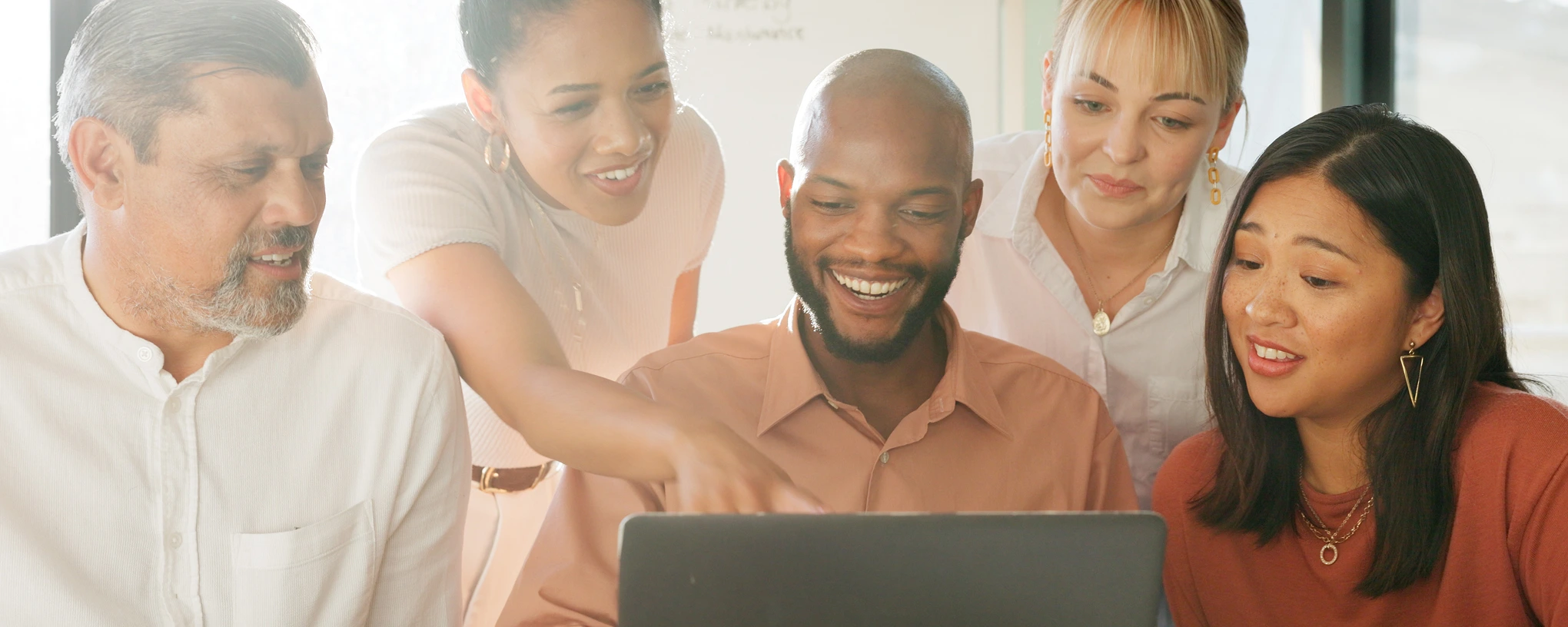 a group of people looking at a laptop