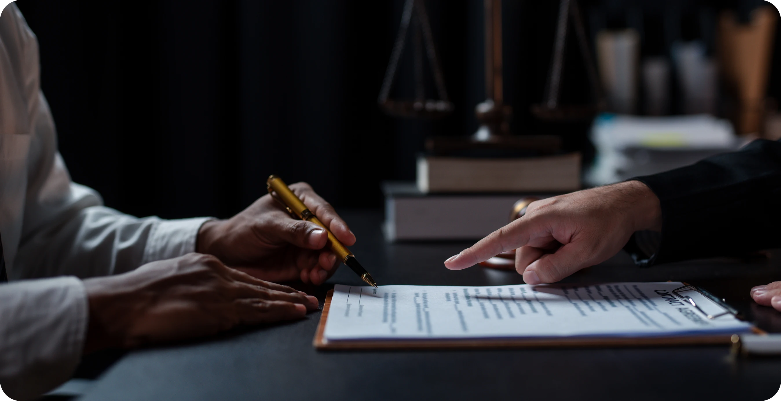 A couple of people sitting at a table with a pen and paper.