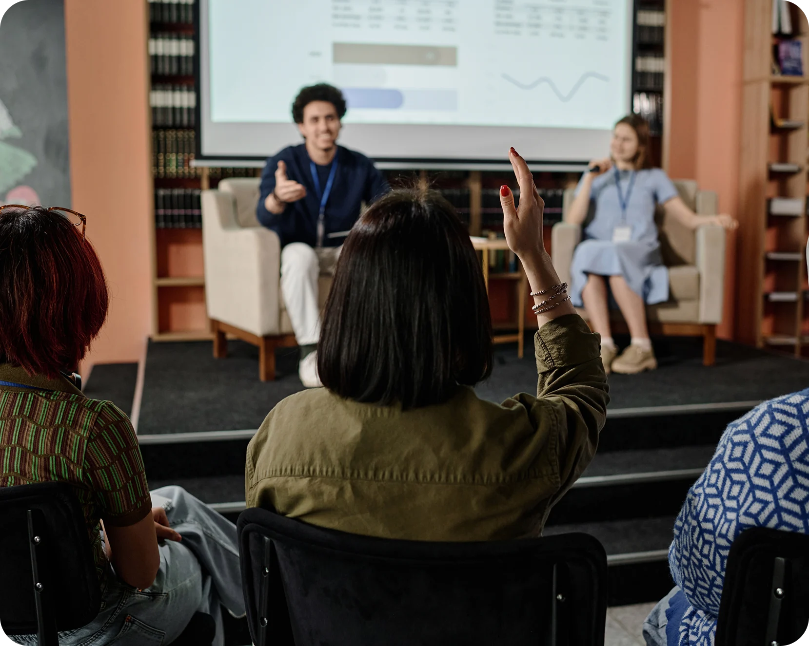 a group of people sitting in chairs and looking at a screen