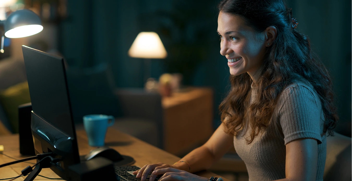 a woman smiling at a computer