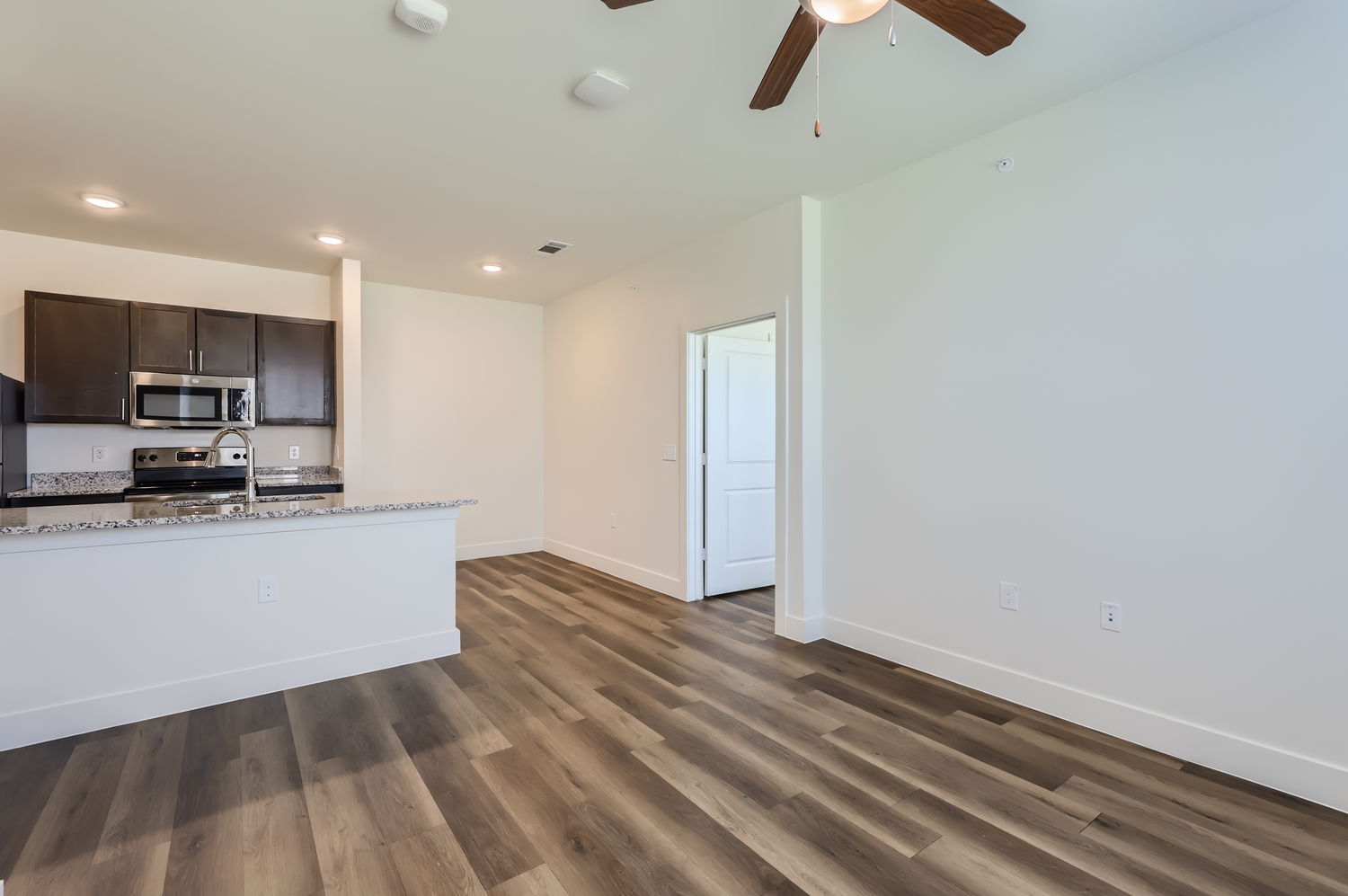 Empty space leading off of the kitchen and into a room 