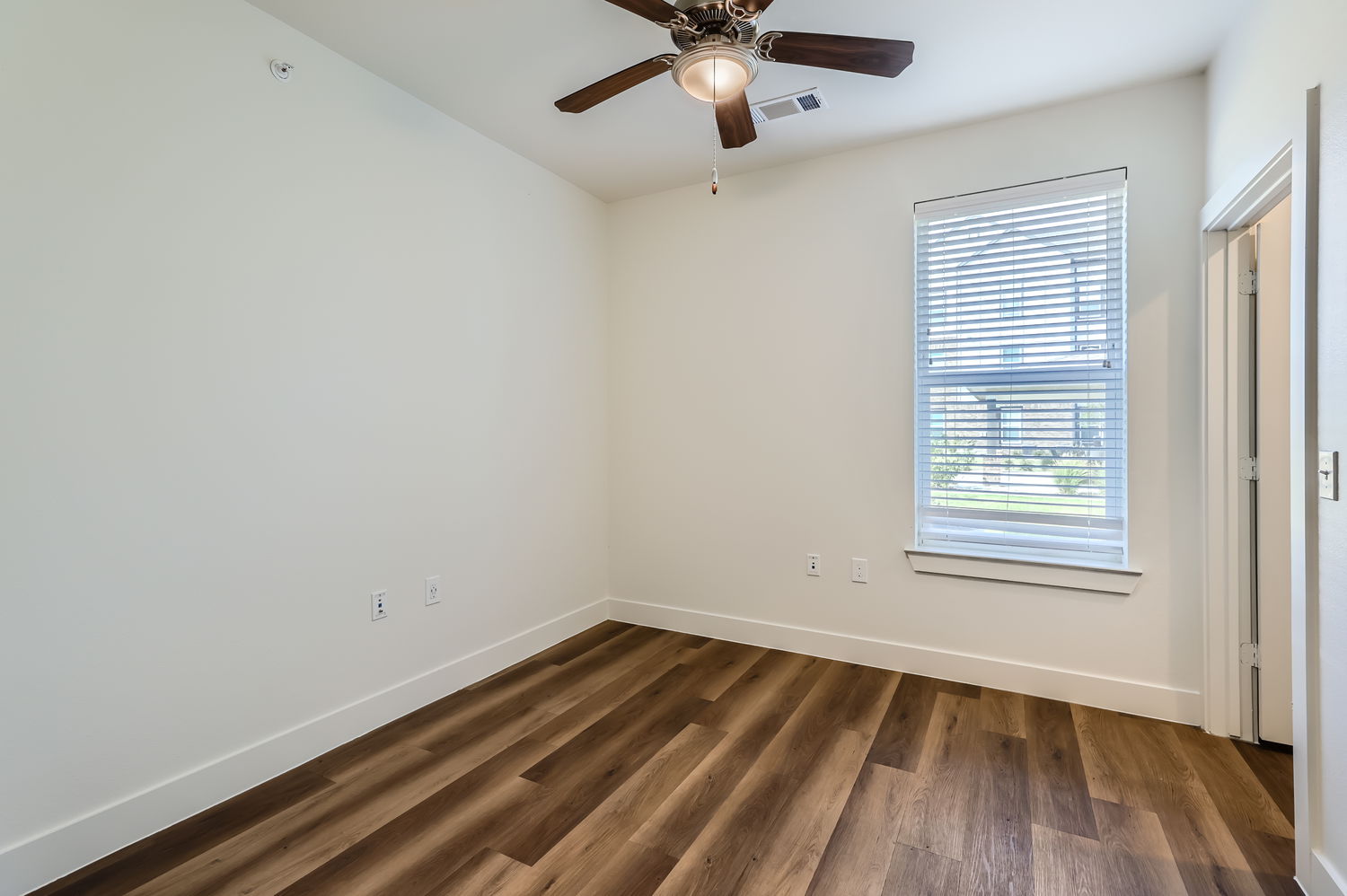 Empty room with one window and ceiling fan