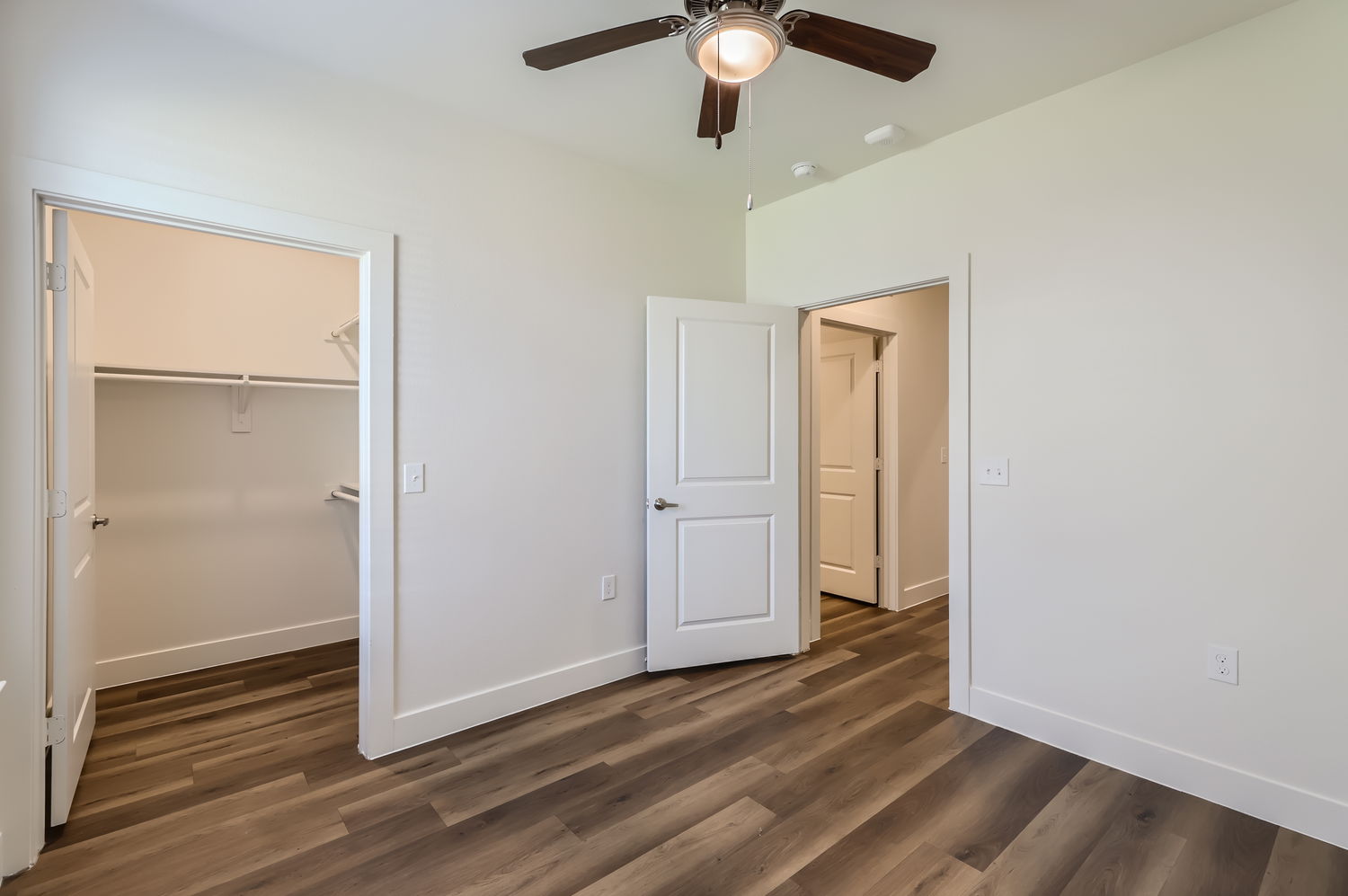 Empty room showing the entry to the closet with racks and shelving