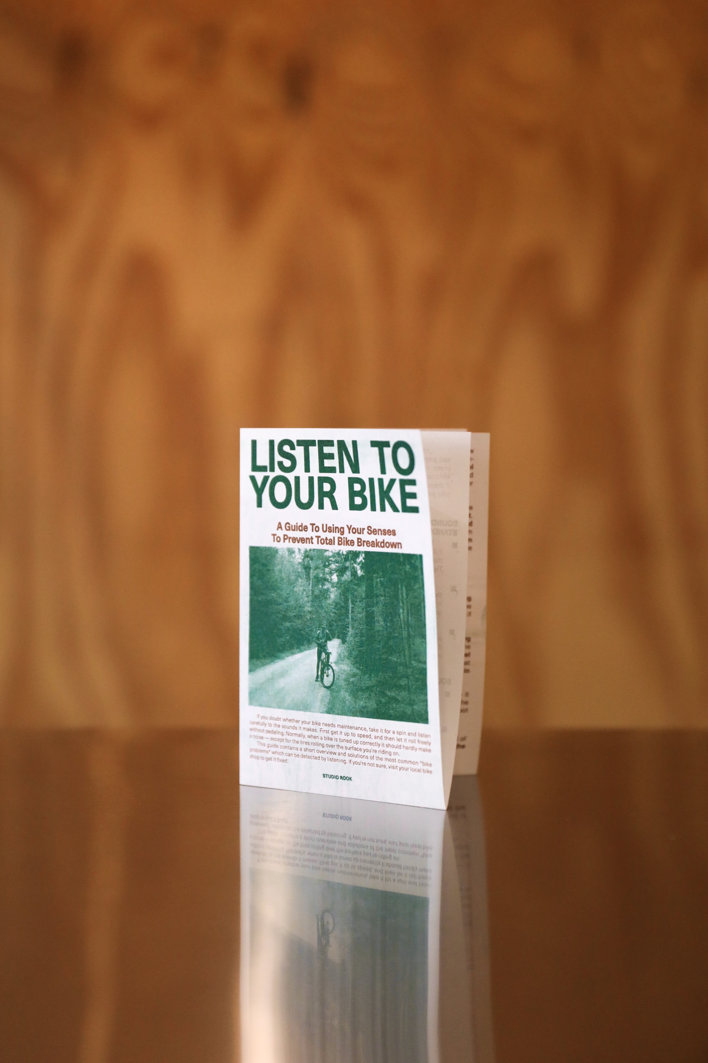 Folded brochure titled 'Listen to Your Bike' with an image of a person cycling on a forest path.