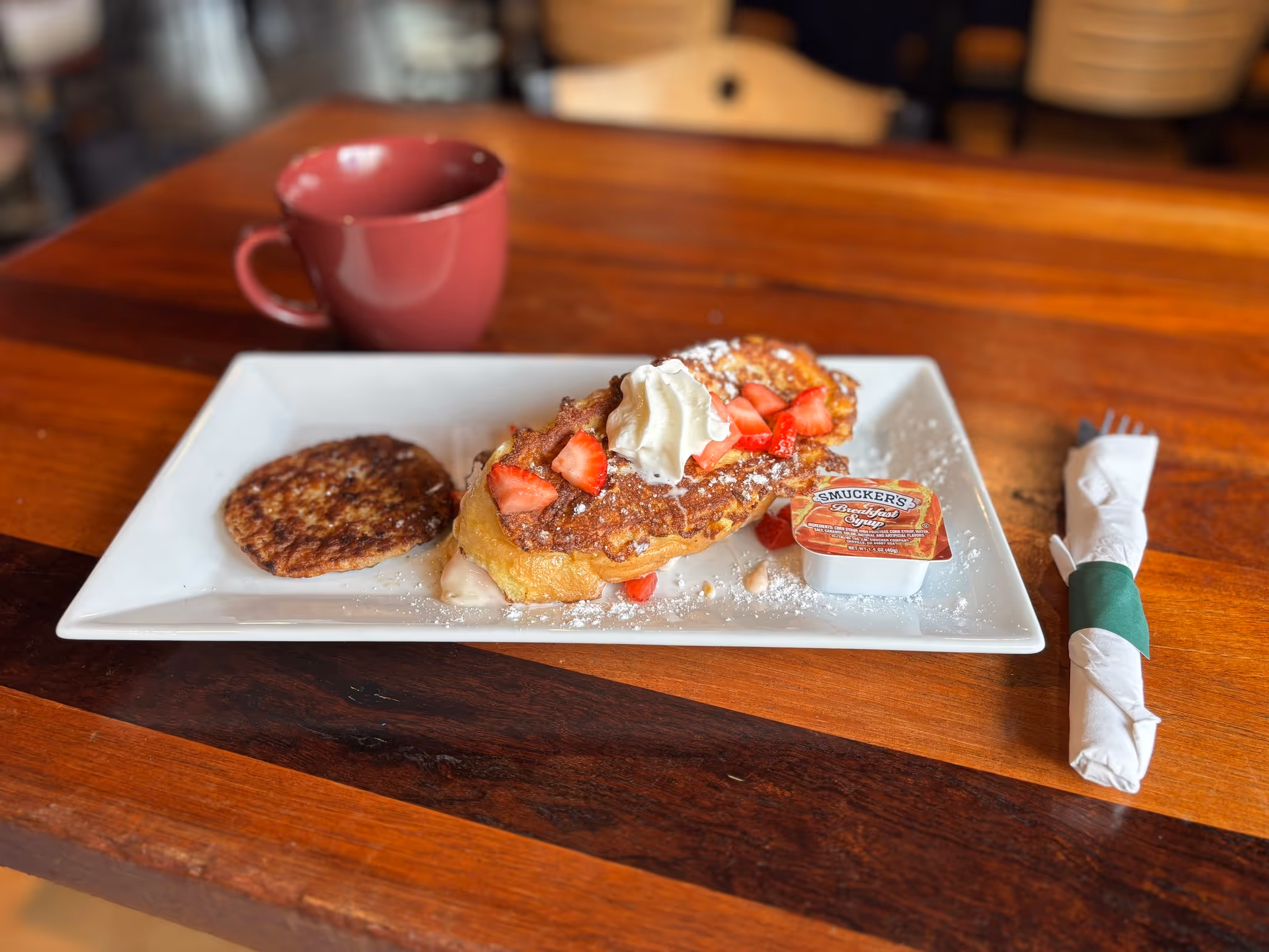 A plate of food with a cup of coffee and a strawberry on top.