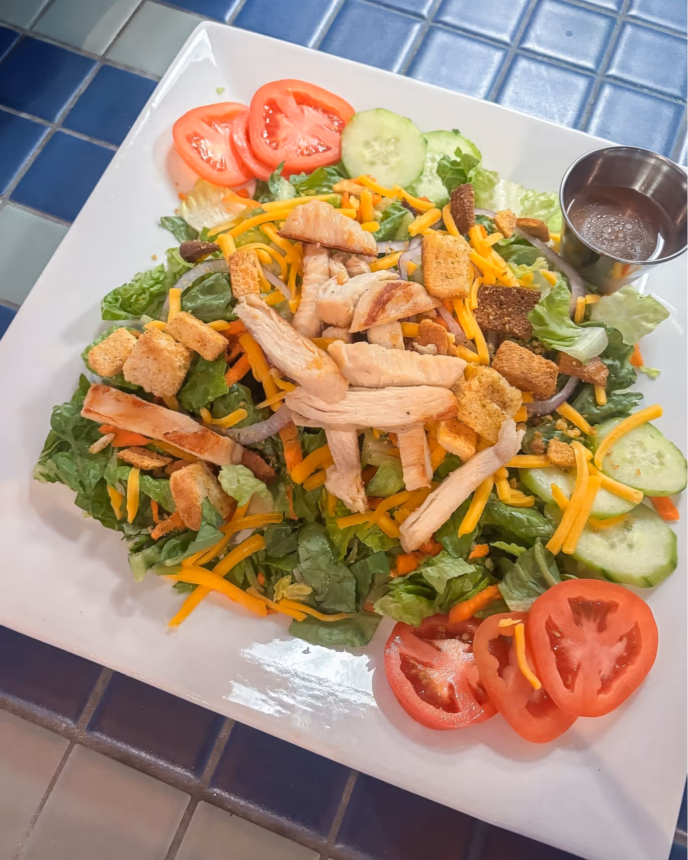 A salad with tomatoes, cucumbers, and cheese.