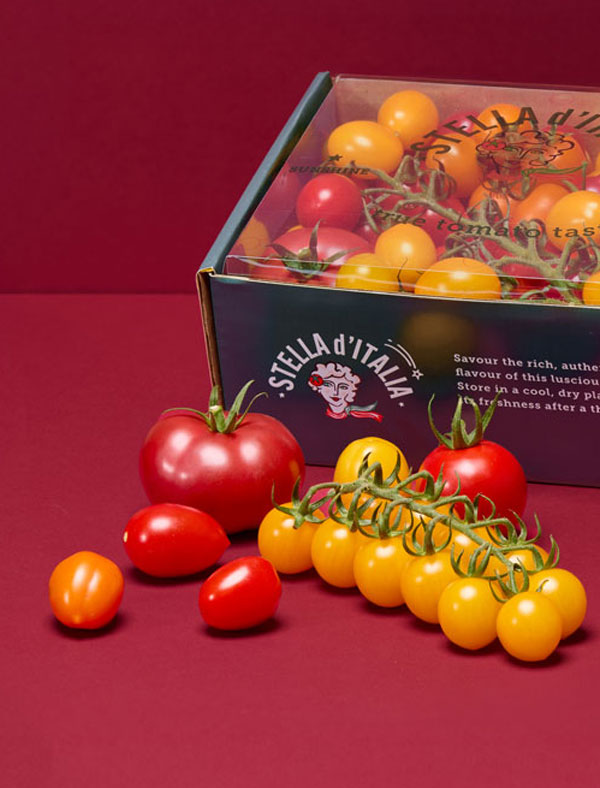 Pattern of green mini cucumbers and a few brown and one yellow cherry tomatoes on a brown background.