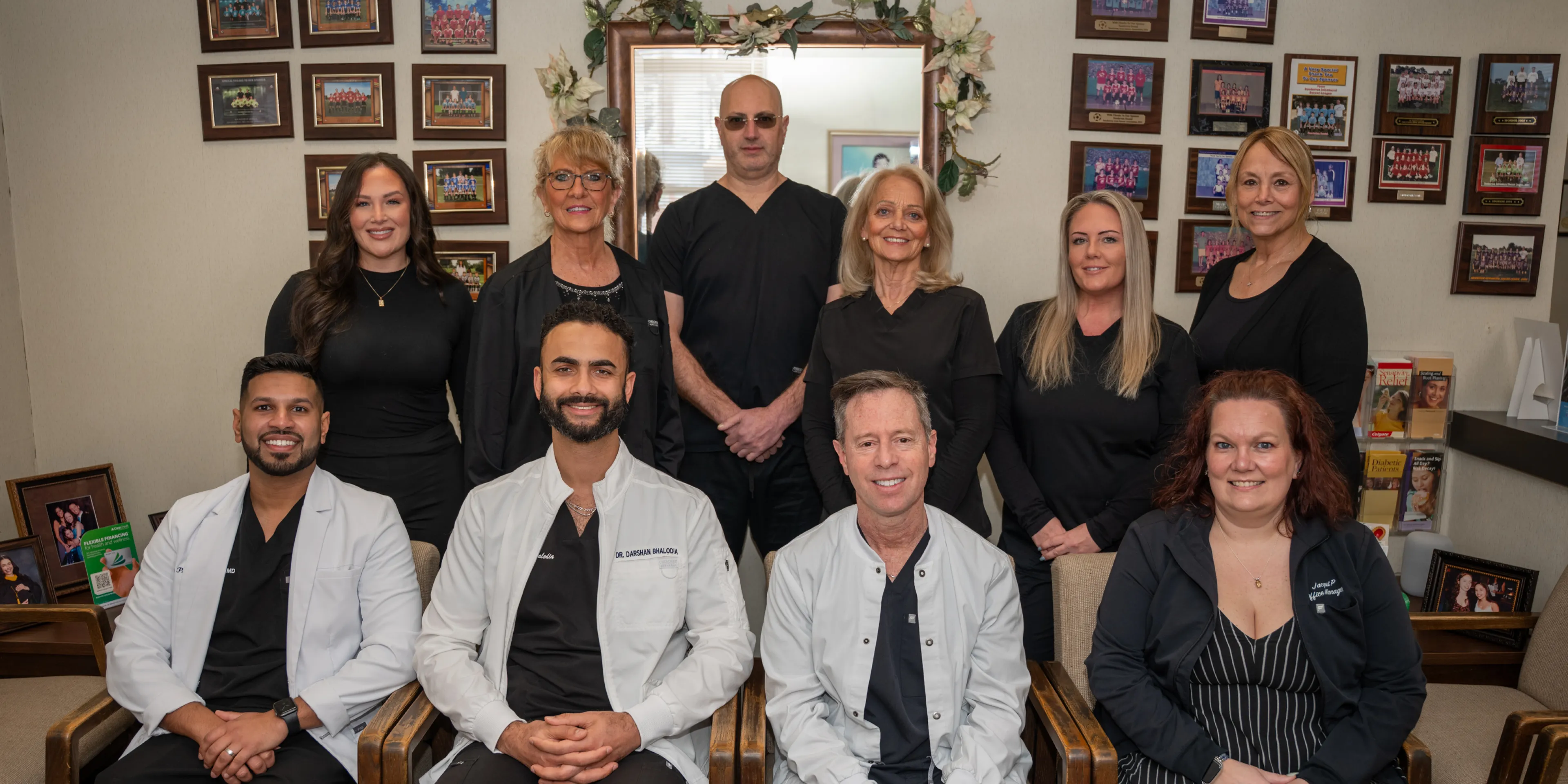 Group of healthcare professionals posing in a room with framed photos on the walls.