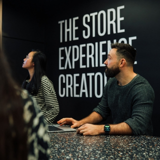 Craftsperson assembling bespoke retail fixture in workshop.