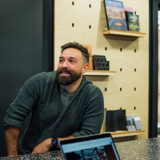 Craftsperson assembling bespoke countertop display unit in workshop.