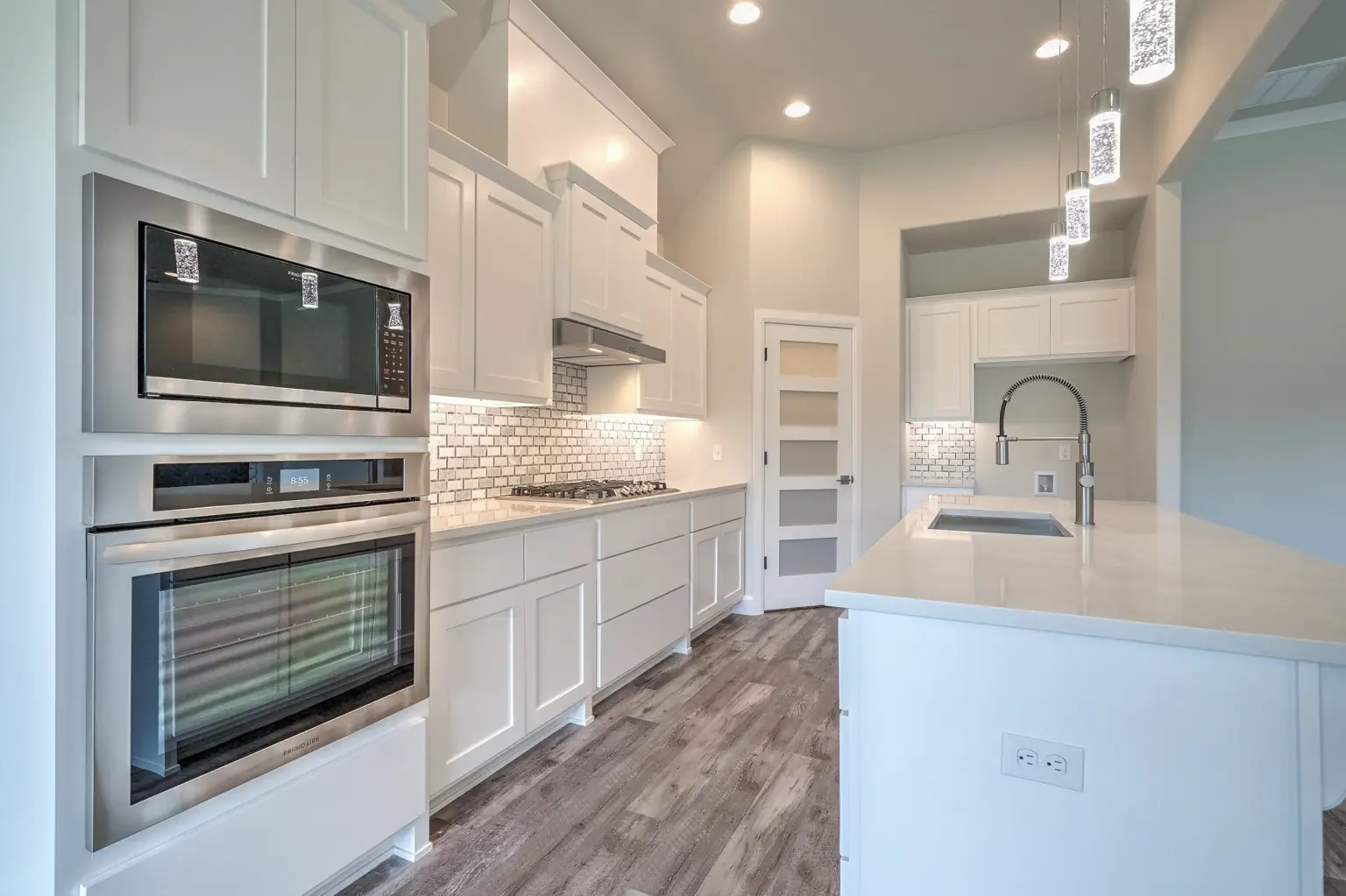 Modern retail or bar buildout with custom counter, bar seating, shelving, and decorative lighting