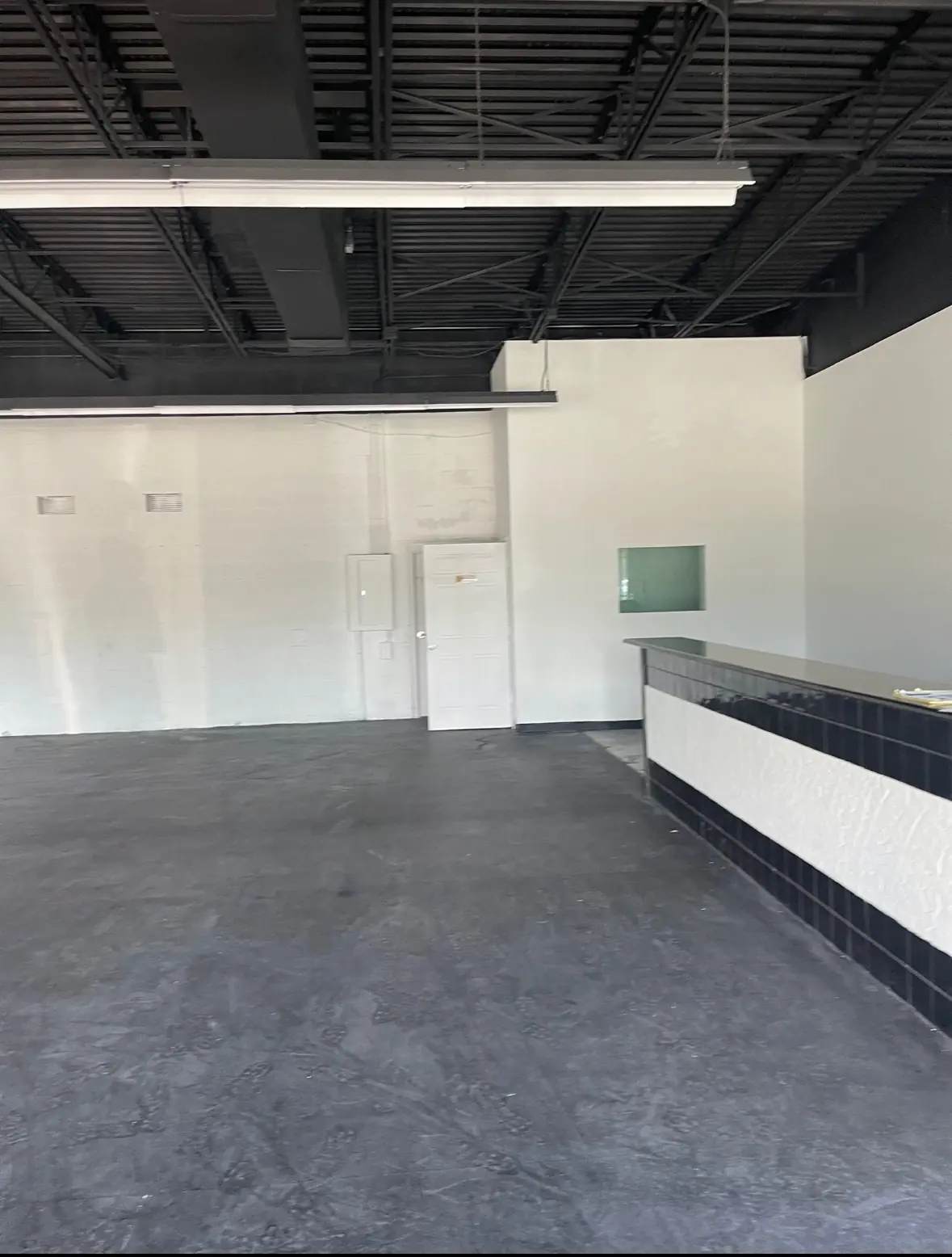 Commercial interior space during buildout with open floor plan, exposed ceiling, and unfinished walls