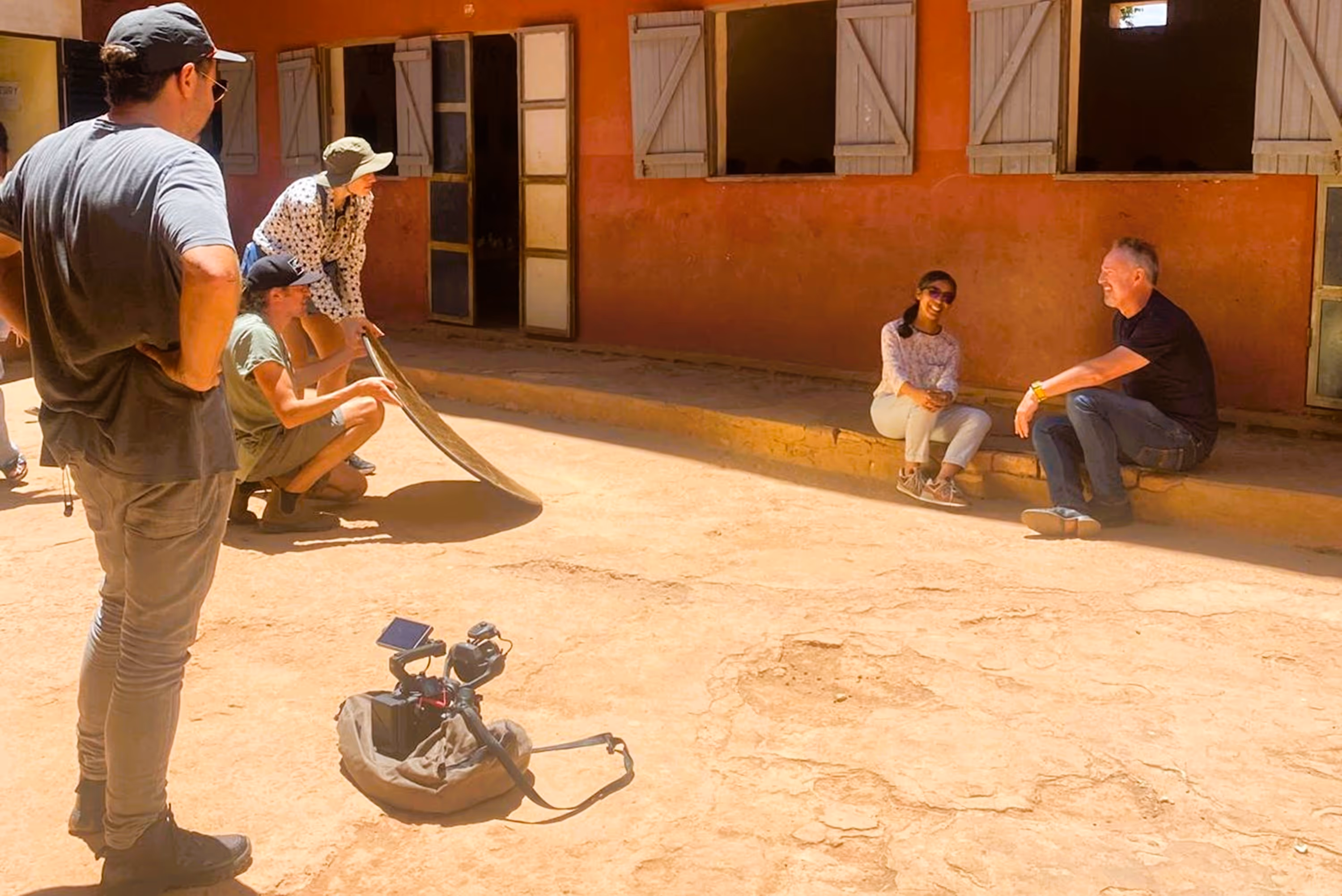 People filming in front of a building.