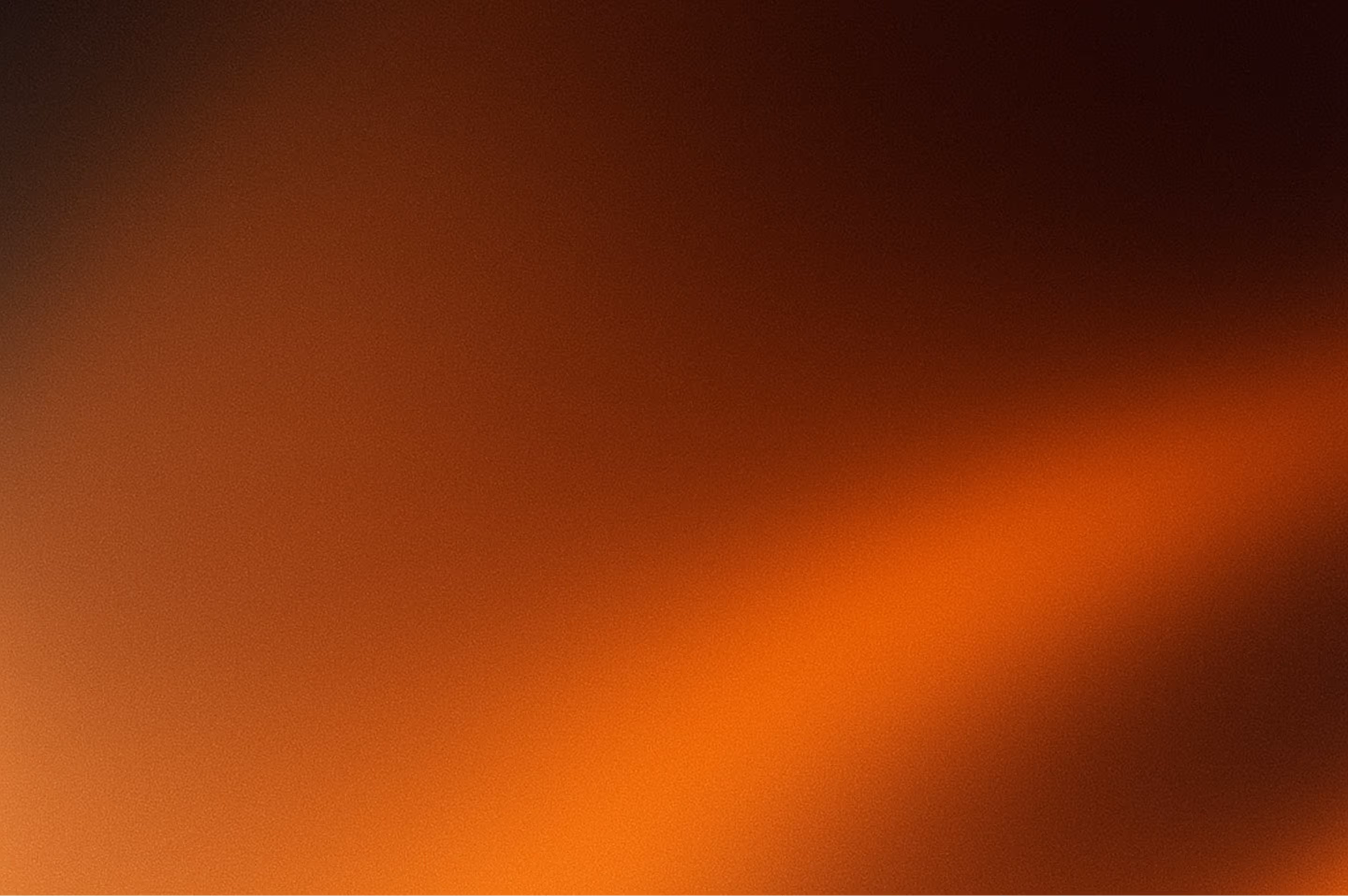 Rozostřený obraz s odstíny oranžové a černé, připomínající oheň nebo žár.