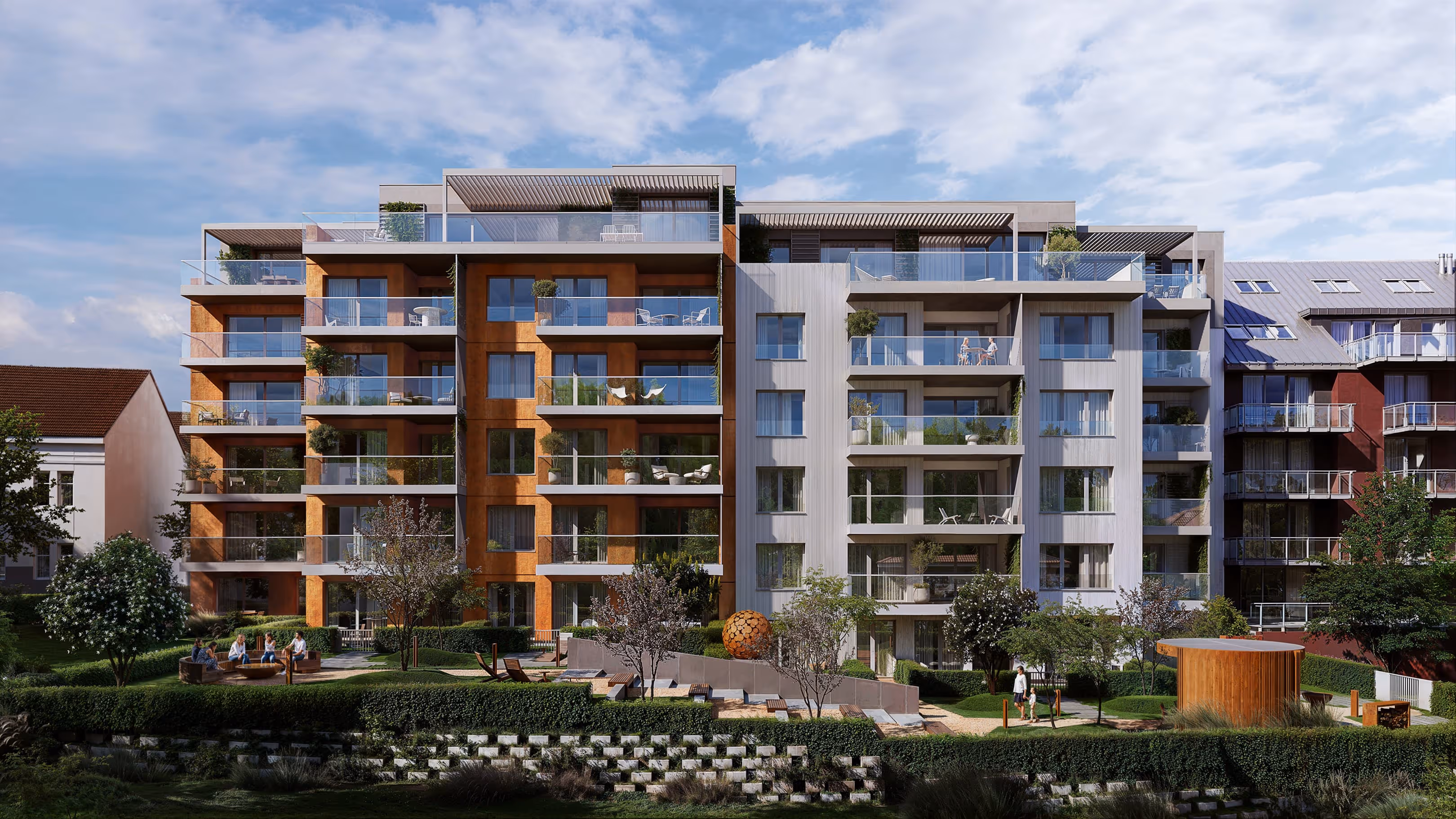 Moderní bytový dům se zelenou zahradou, terasami a lidmi odpočívajícími venku.