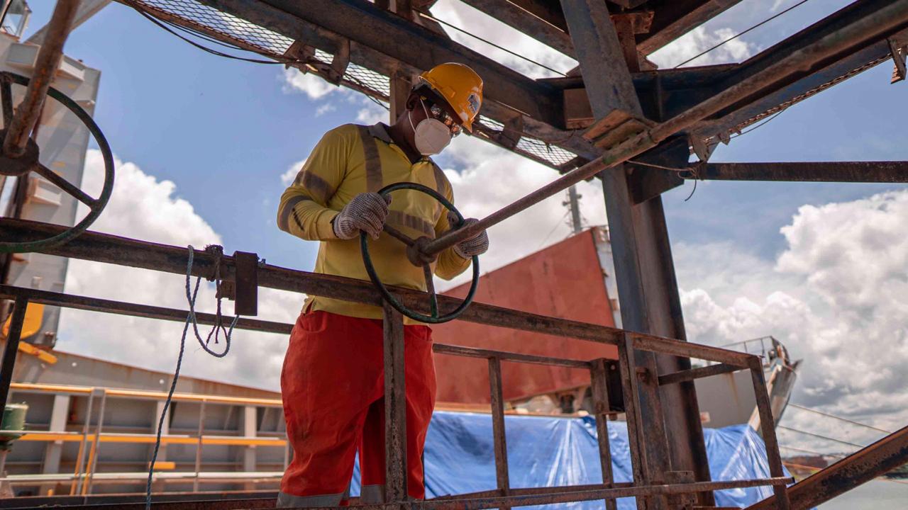 Colaborador de DEPSA usando casco, guantes y mascarilla de protección, operando el timón de un equipo