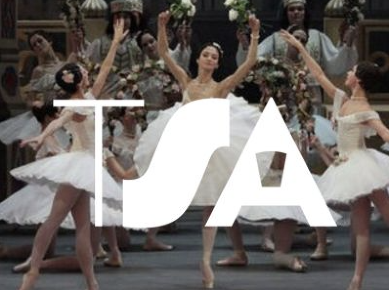 Ballet dancers in white tutus performing on stage with the large white letters TSA overlaid on the image.