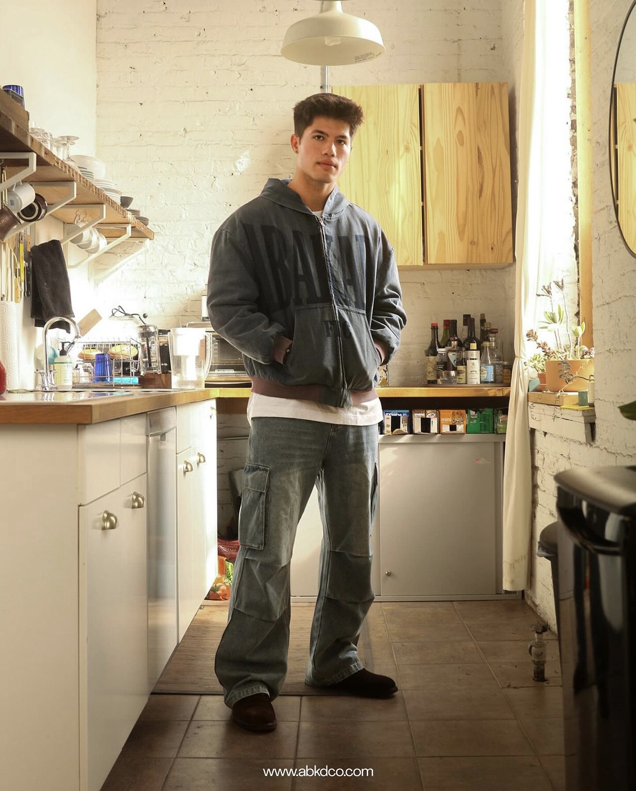 Luke Embers posing full body in an Abakada outfit.