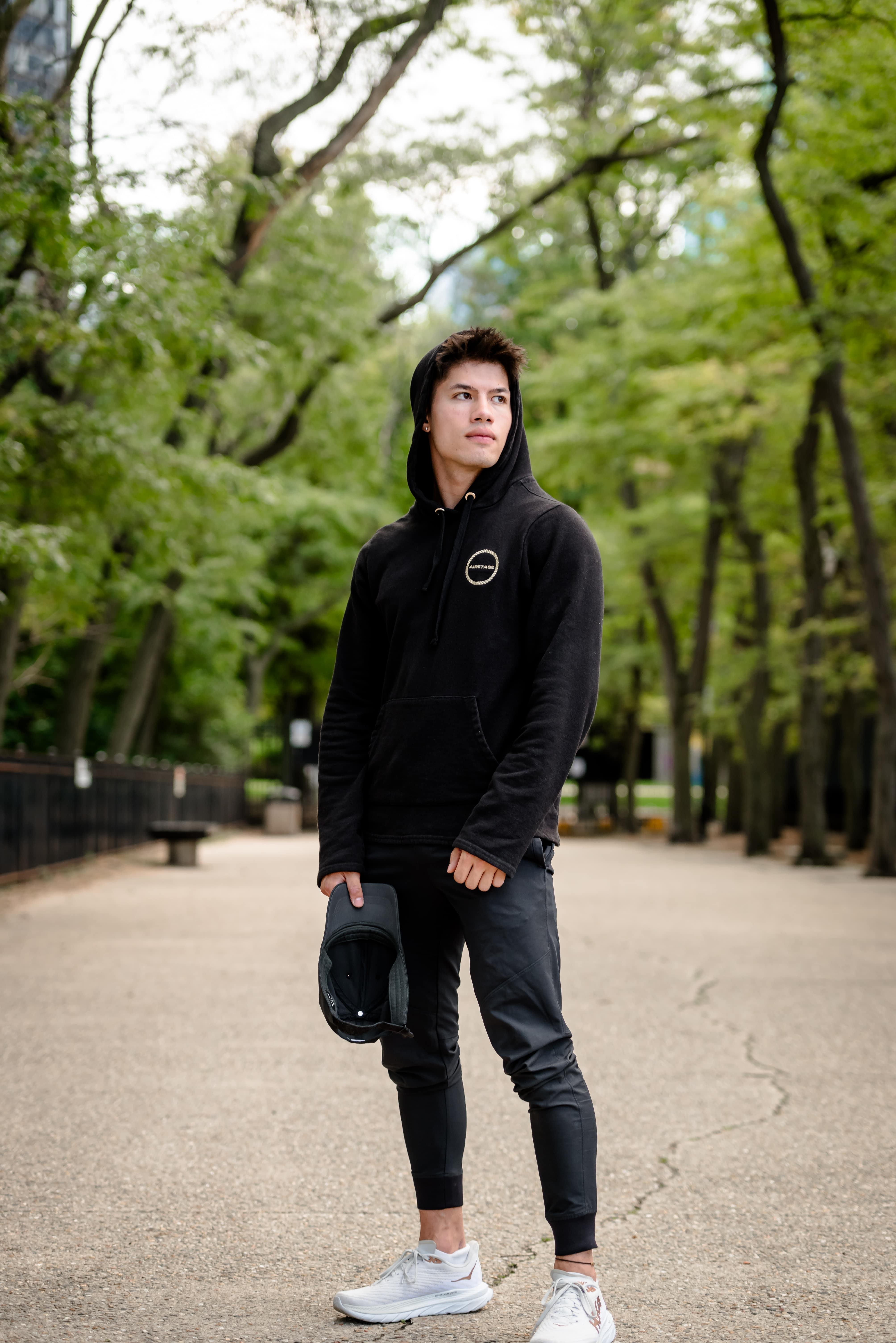 Luke Embers posing with a hoodie and hat in hand.