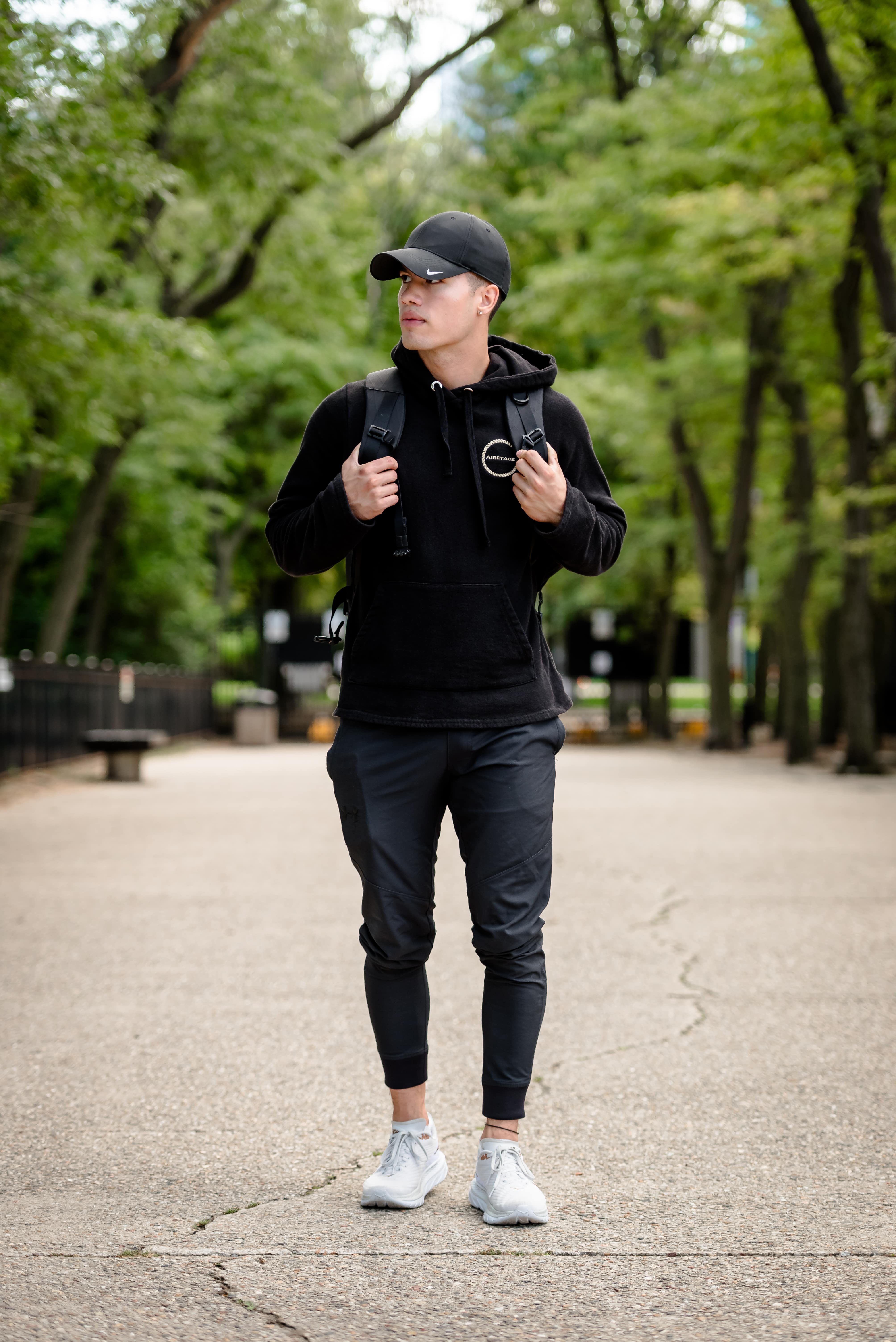 Luke Embers walking outside with his hands on his backpack straps.