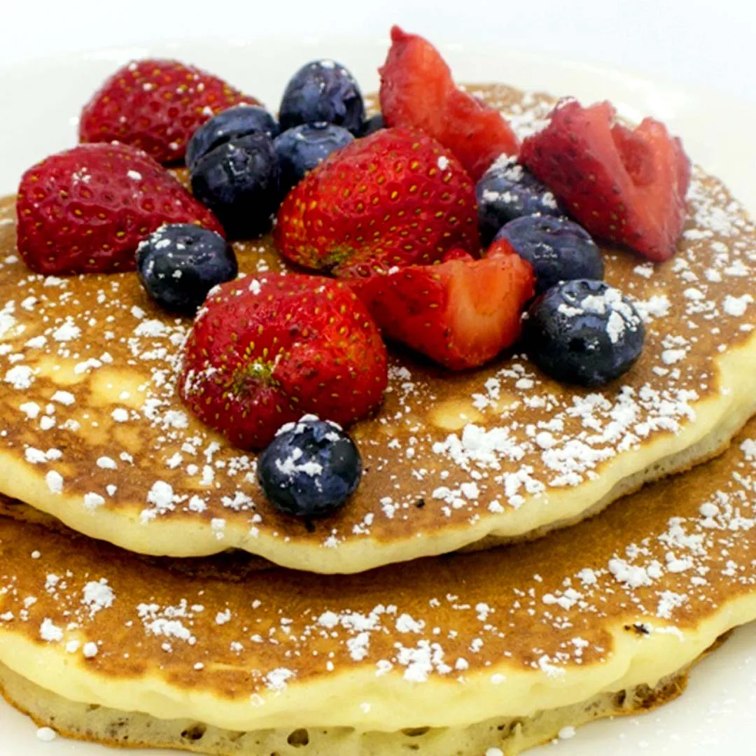 A couple of pancakes with berries, blueberries and strawberries