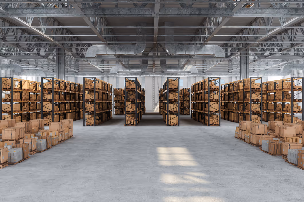 Large warehouse interior with tall metal shelves filled with stacked cardboard boxes and pallets on concrete floor.
