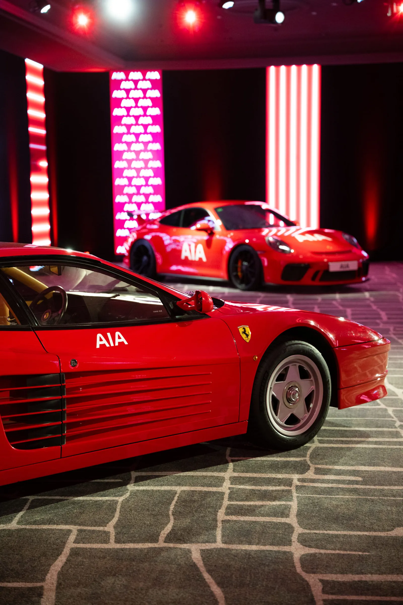 Red Ferrari hypercars displayed inside the Hotel Arts ballroom for a corporate conference
