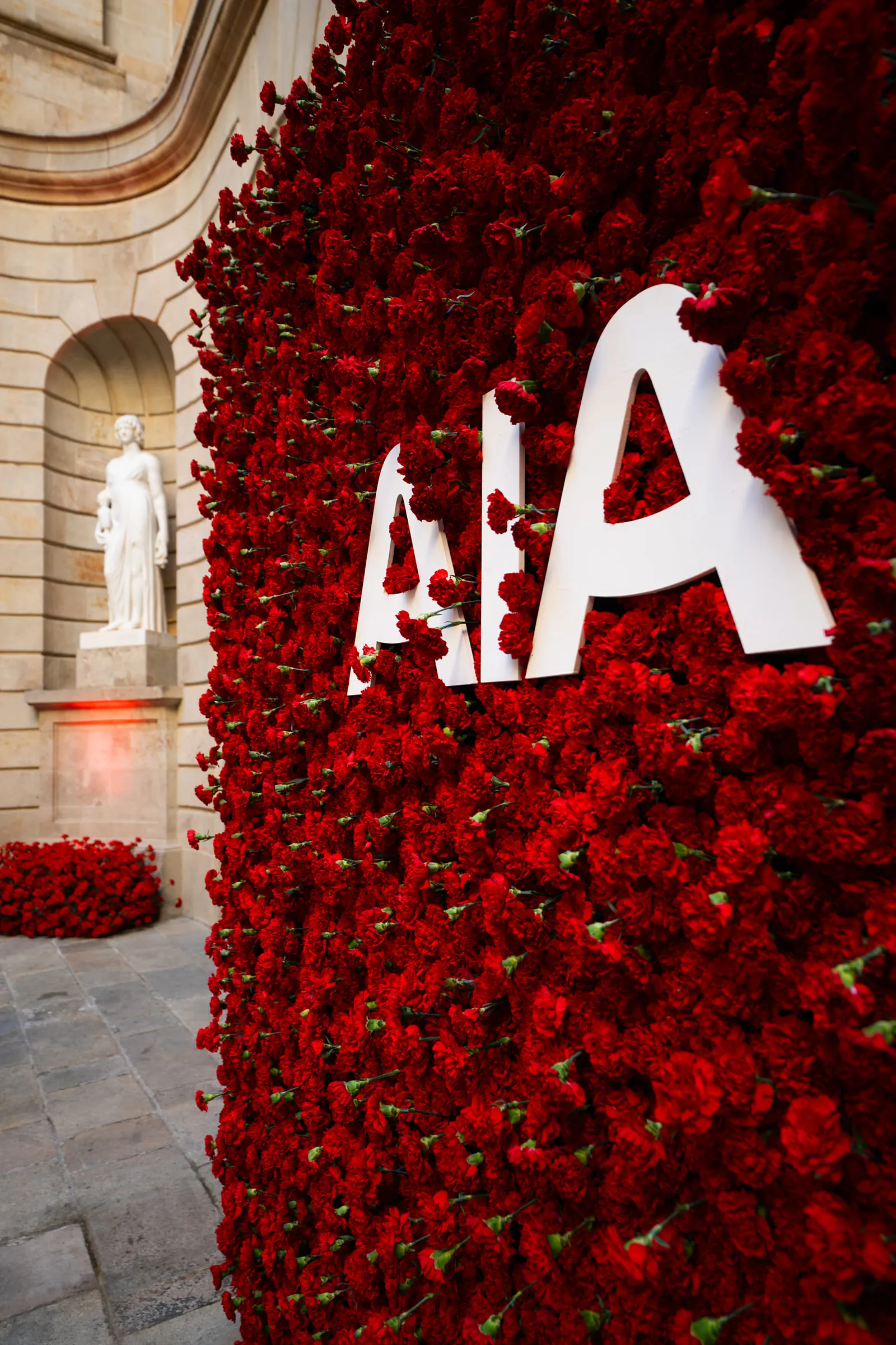 Red rose flower wall with the AIA logo at the gala dinner in La Llotja de Mar