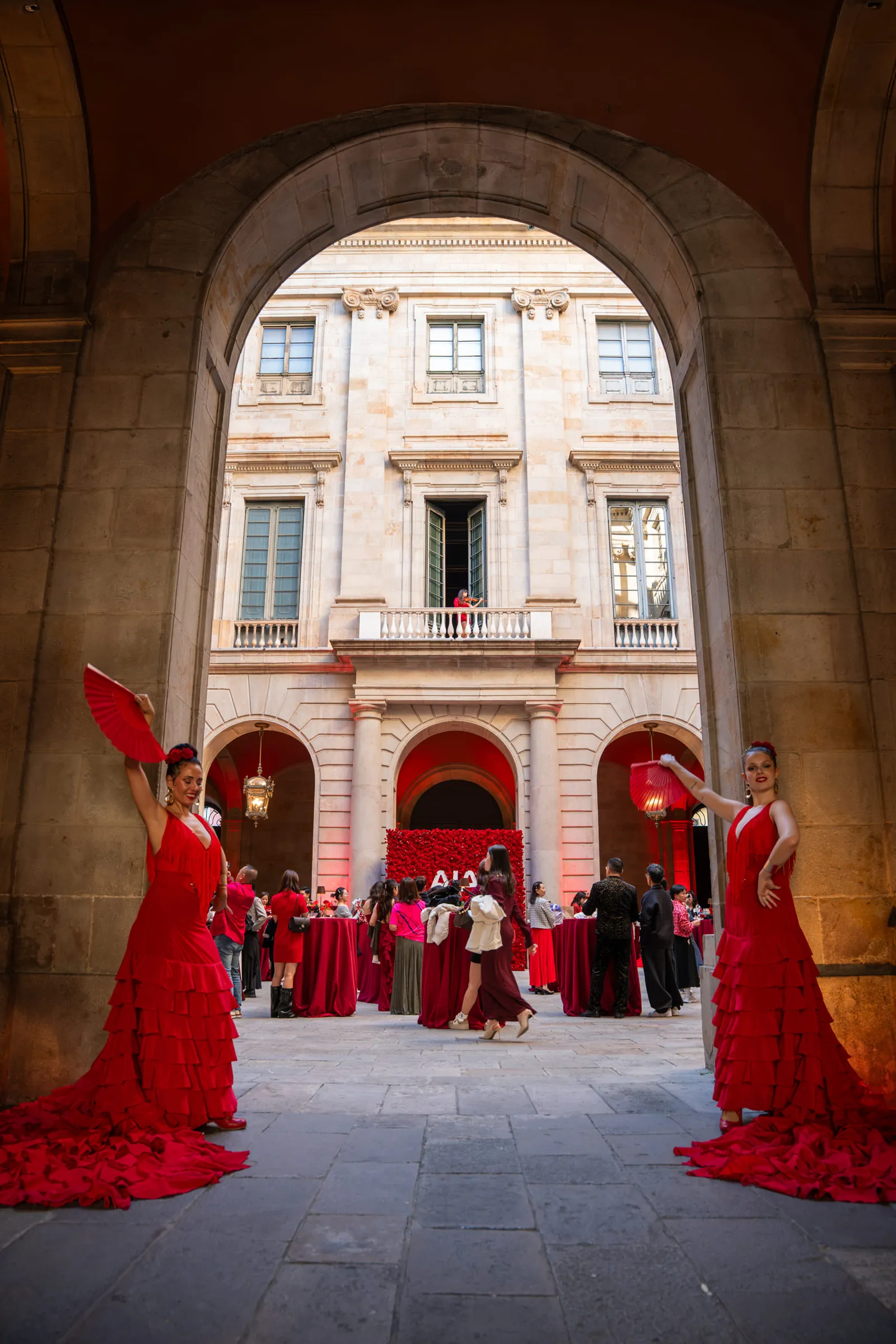 Flamenco dancers in red welcoming guests under the arches of La Llotja de Mar