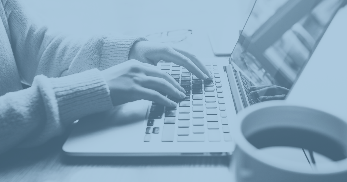 Eine Person sitzt am Laptop mit blauem Filter