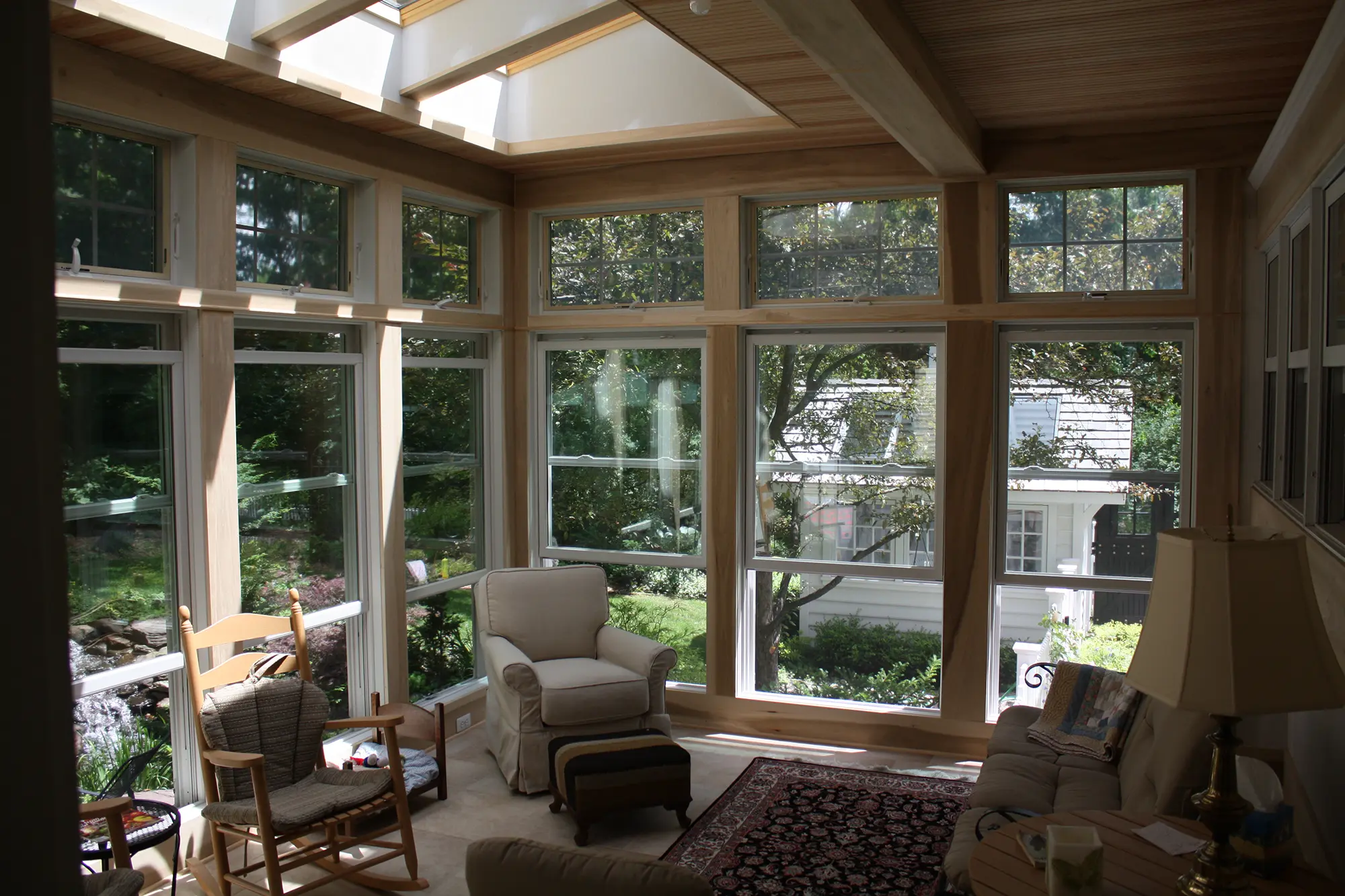 Bright sunroom with large windows and cozy seating