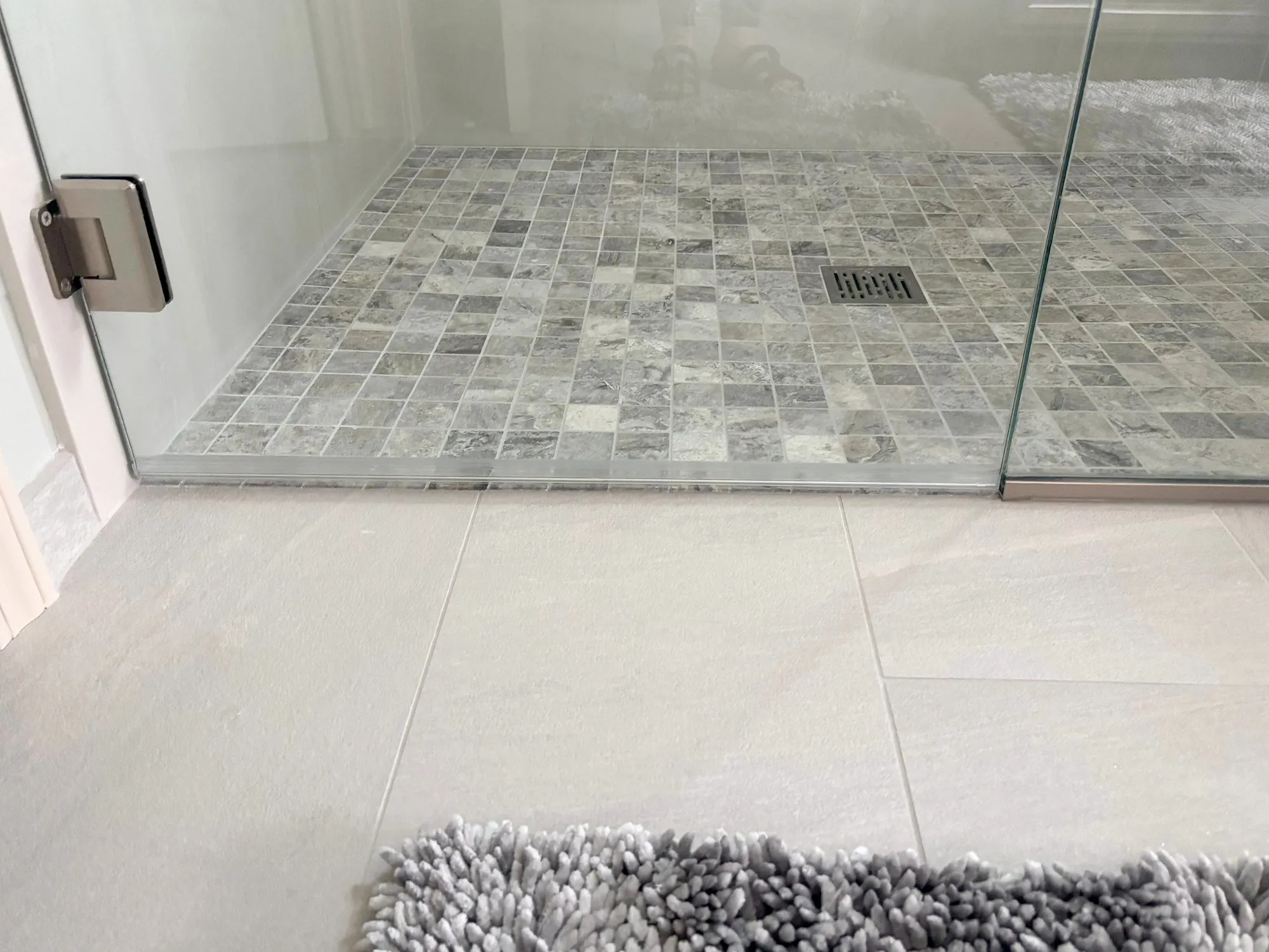 Tiled floor and gray bath mat