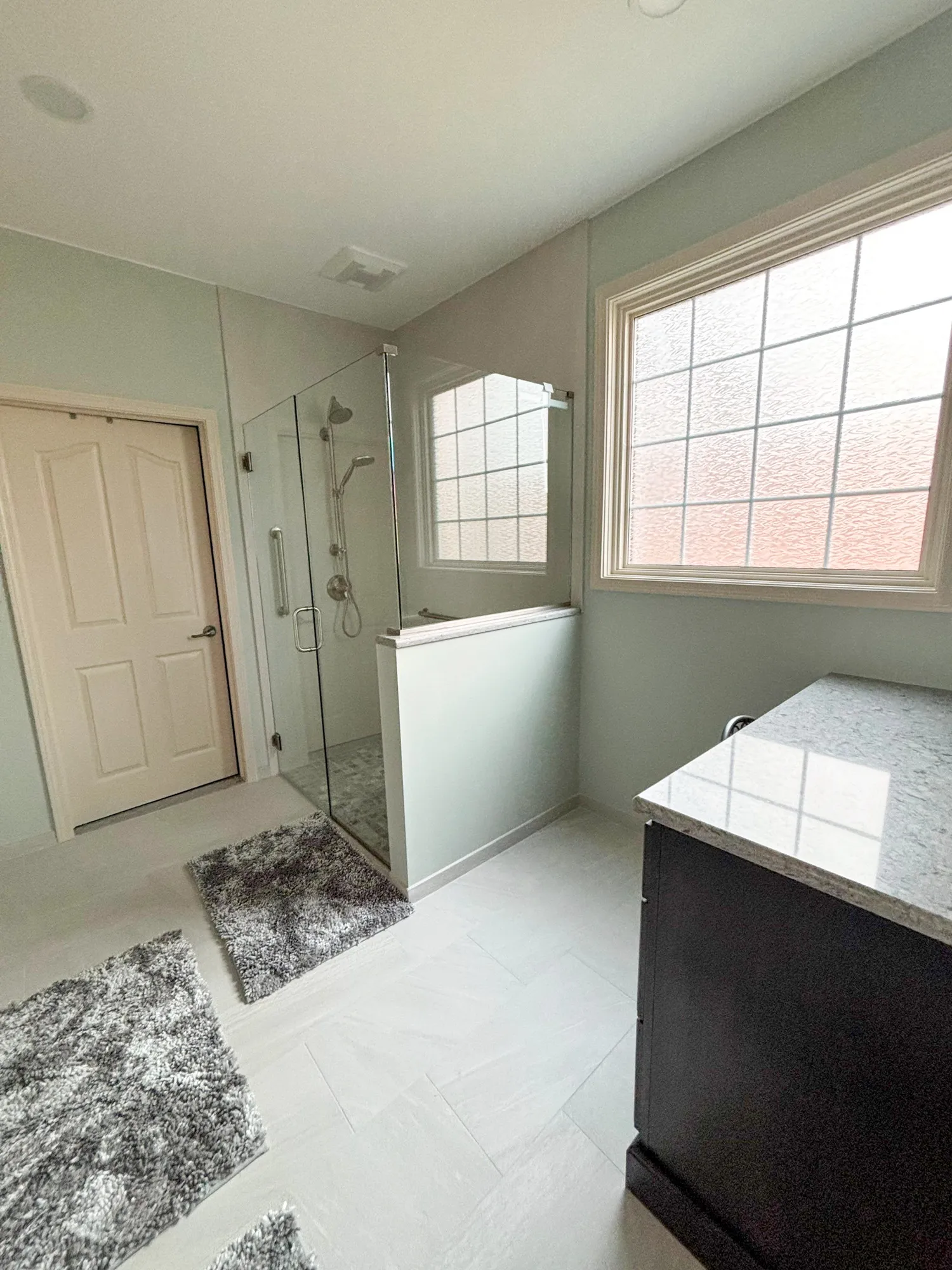 Modern bathroom with glass shower and large frosted window