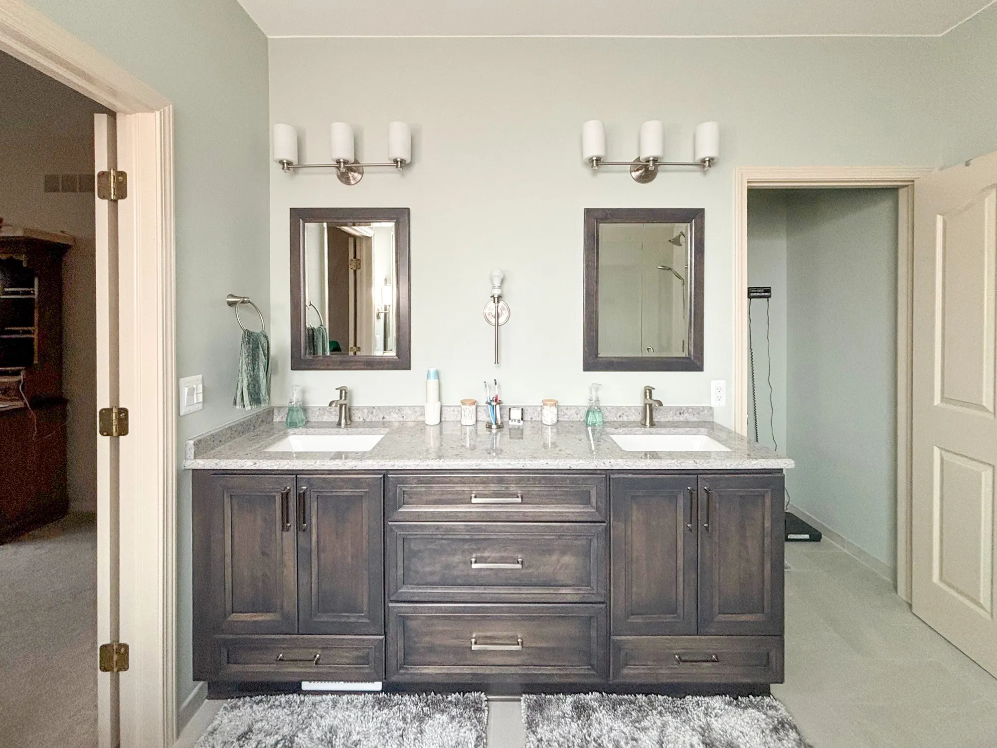 Double-sink bathroom vanity with dark wood cabinets and two mirrors
