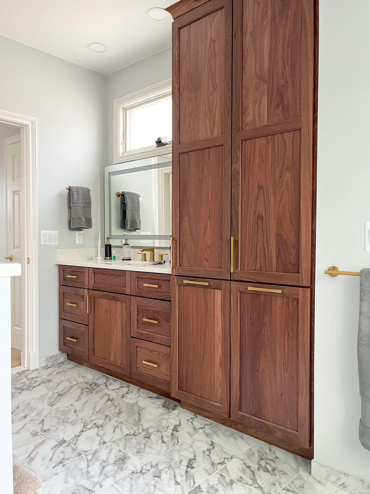 Bathroom with wooden cabinets and marble floor