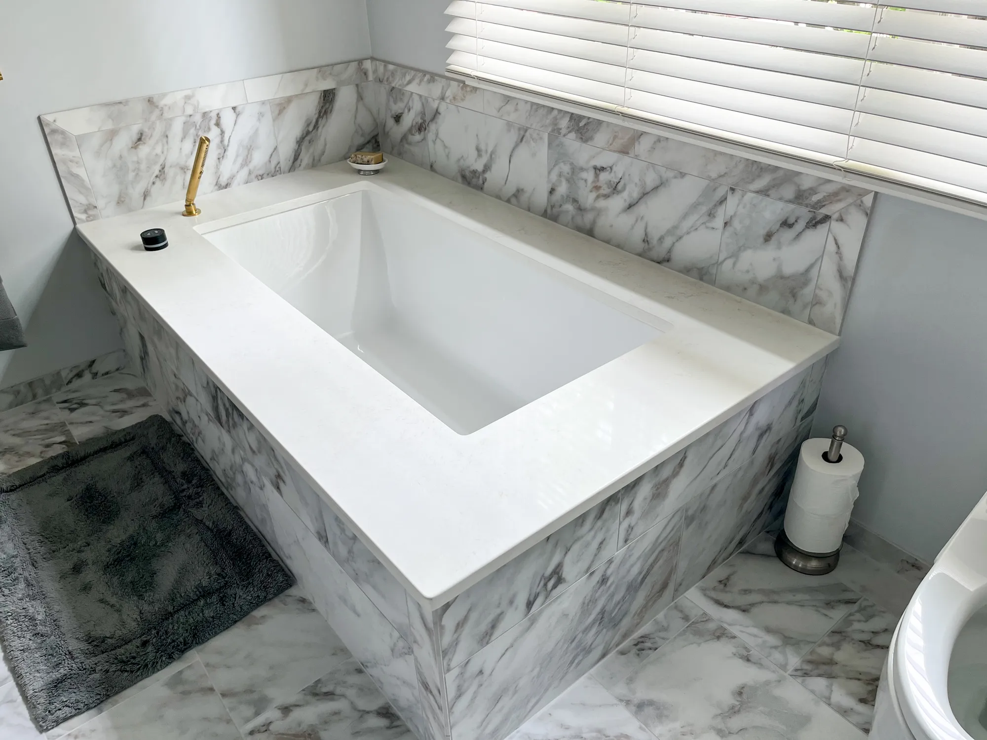 Marble bathtub with gold faucet in a modern bathroom