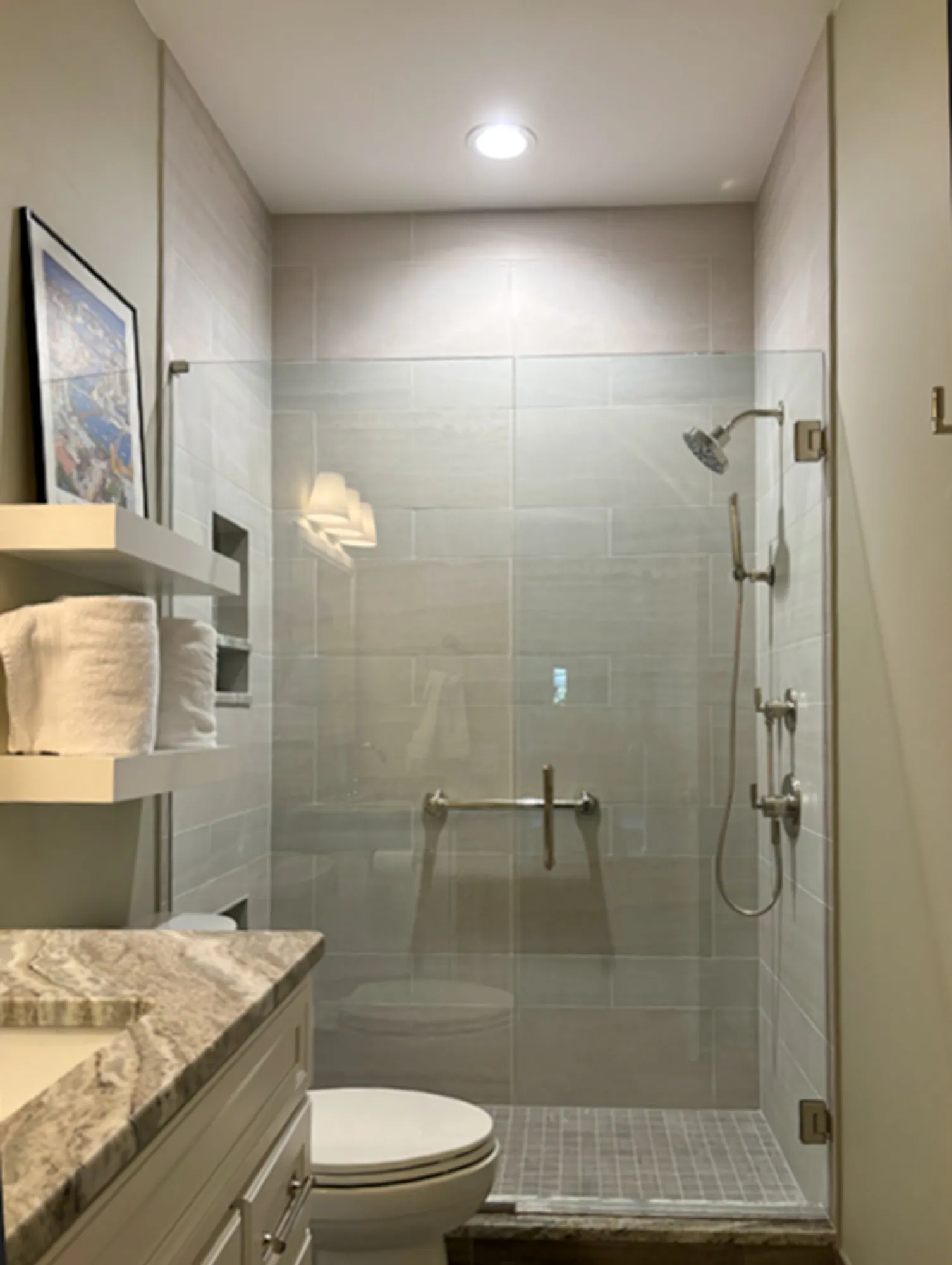 Modern bathroom renovation in plymouth, mi with a glass door shower, gray tiles, and stylish fixtures.