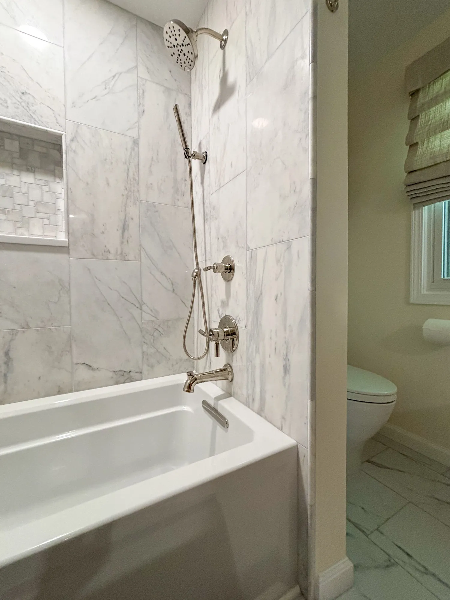 luxury bathroom featuring a marble shower with rainfall showerhead and a freestanding tub