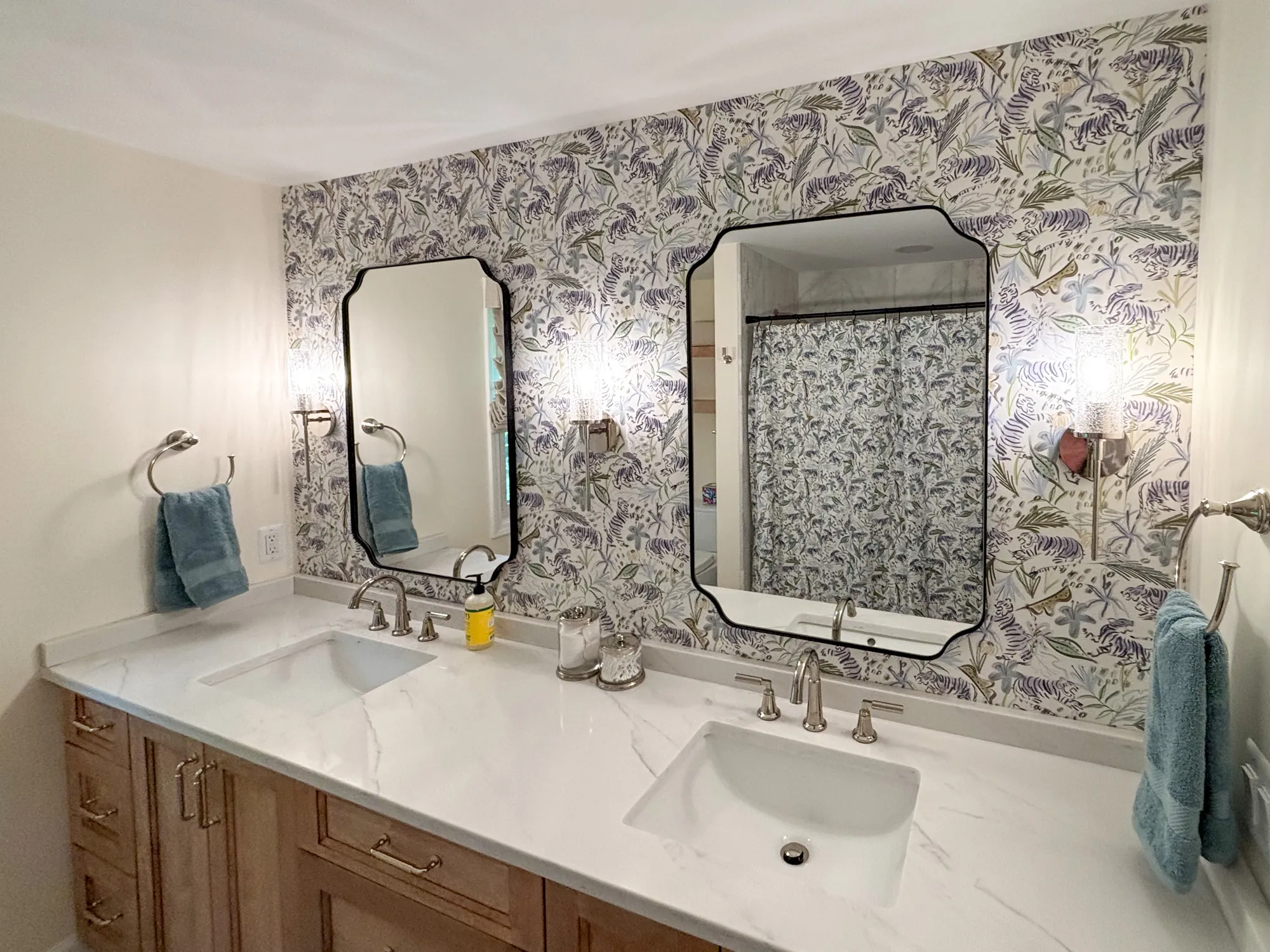 Modern bathroom with floral wallpaper, dual sinks, and elegant fixtures